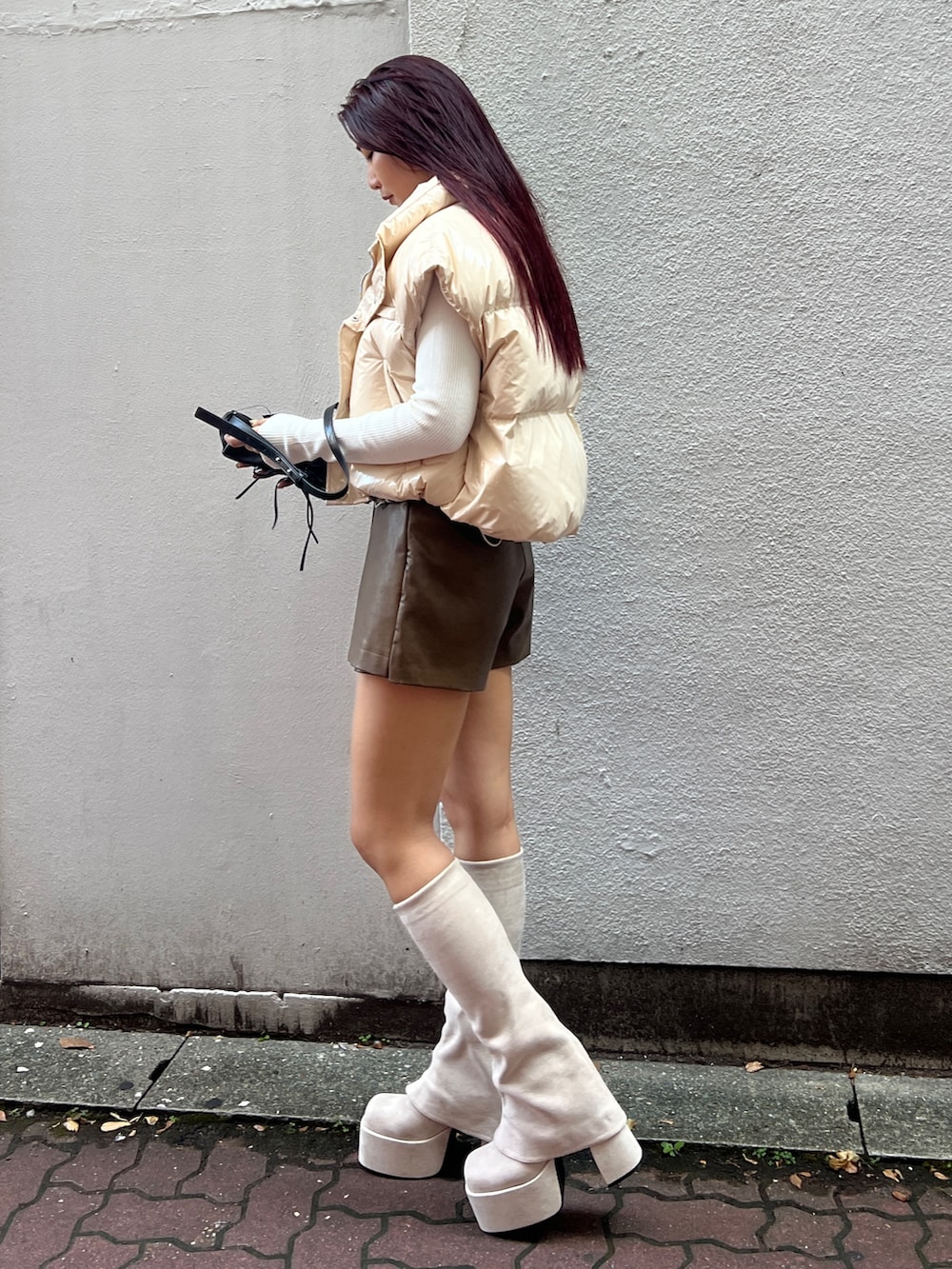 ホワイト系のダウンベスト、ホワイト系のニット/セーター、ブラウン系のその他パンツを着用したレディースの秋コーディネートの2枚目の写真