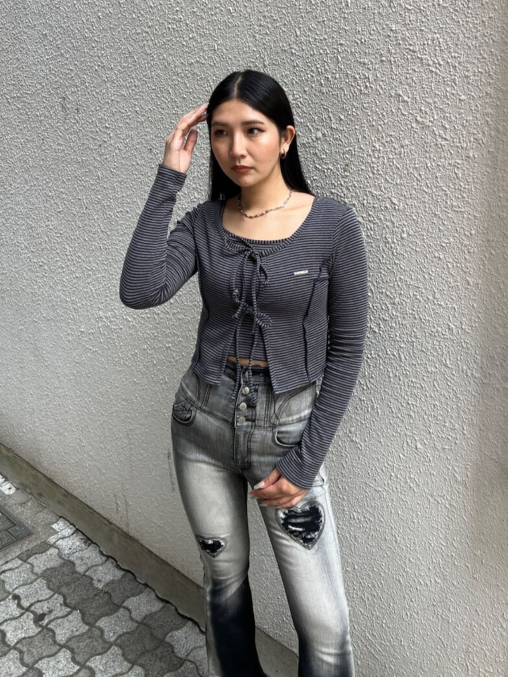 ブラック系のデニムパンツ、ブルー系のTシャツ/カットソー、ブラック系のハンドバッグを着用したレディースの夏コーディネートの4枚目の写真