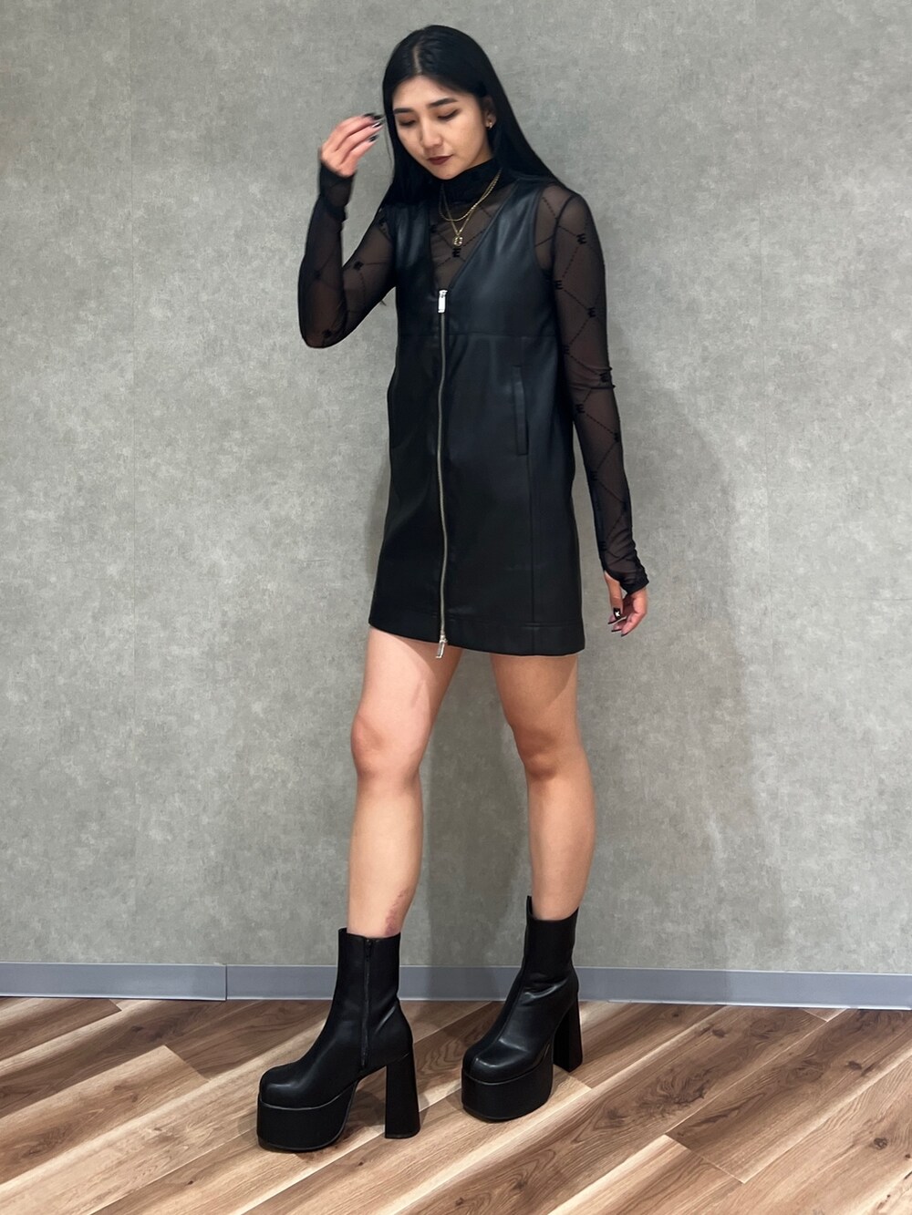 ブラック系のワンピース、ブラック系のTシャツ/カットソー、ブラック系のブーツを着用したレディースの秋コーディネートの3枚目の写真