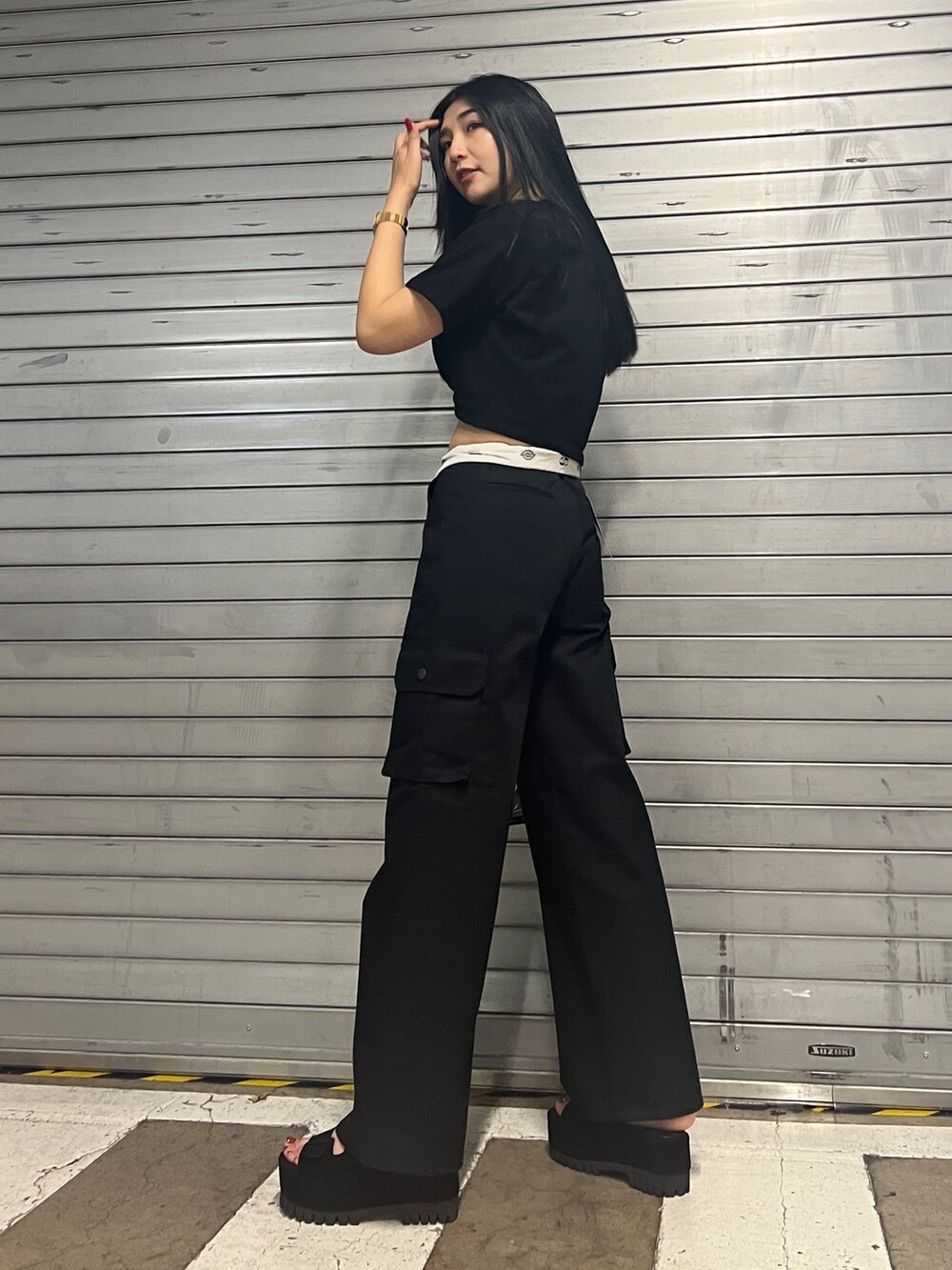 ブラック系のカーゴパンツ、ブラック系のサンダル、その他のハンドバッグを着用したレディースの夏コーディネートの3枚目の写真