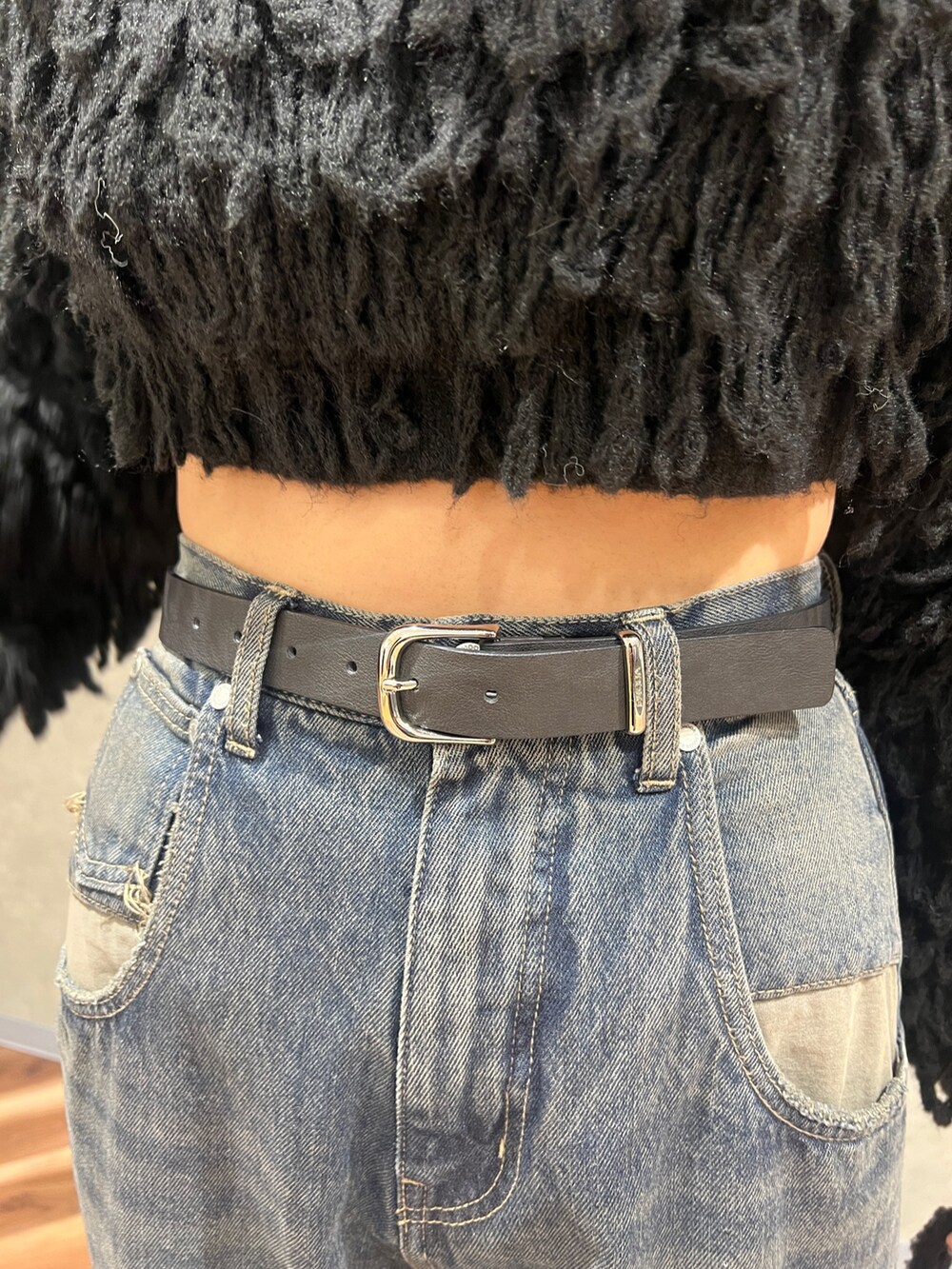 ブラック系のニット/セーター、ブルー系のデニムパンツ、ブラック系のブーツを着用したレディースの冬コーディネートの6枚目の写真