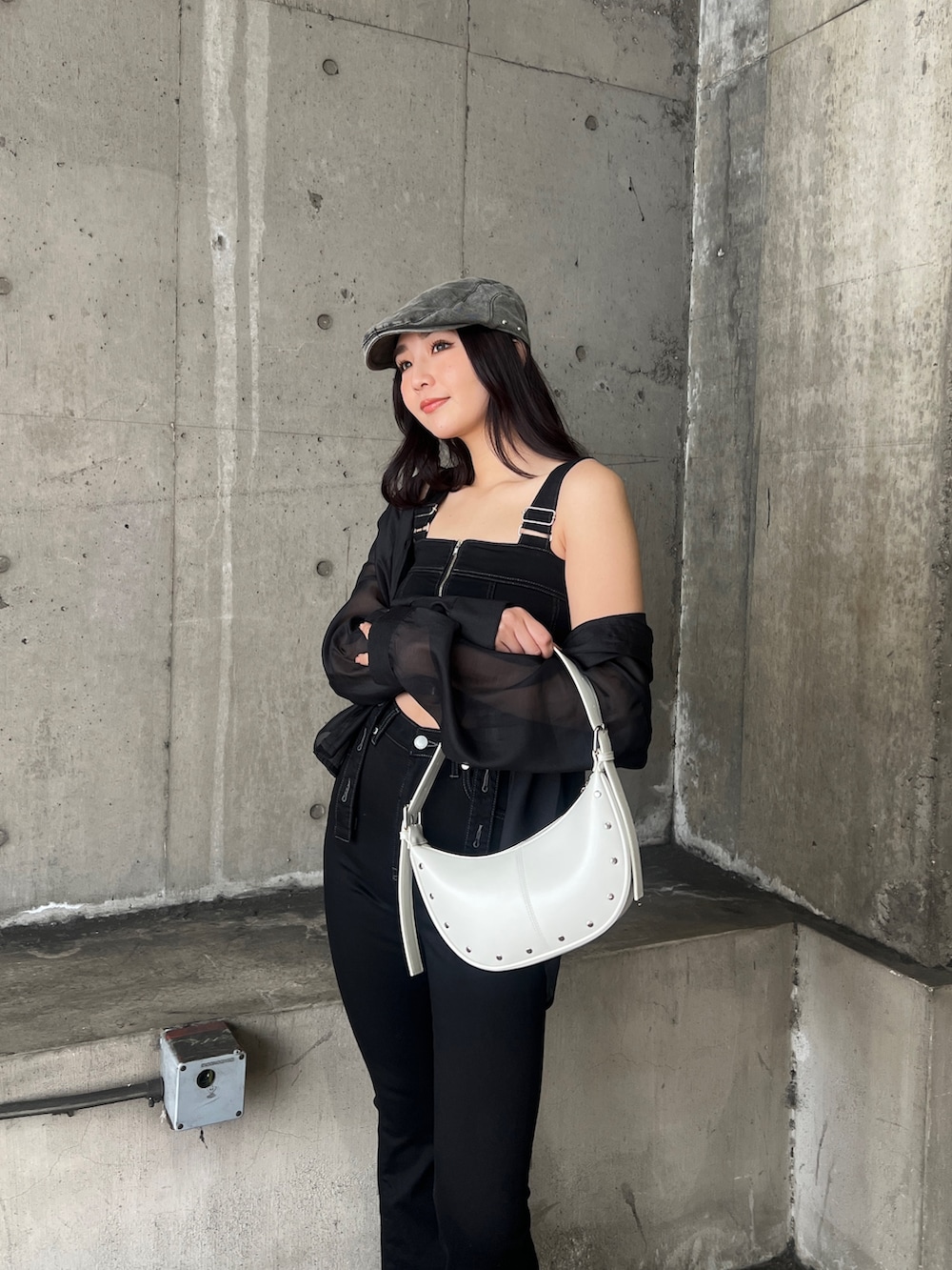 ブラック系のサロペット/オーバーオール、ブラック系のシャツ/ブラウス、ホワイト系のハンドバッグを着用したレディースの春コーディネートの7枚目の写真