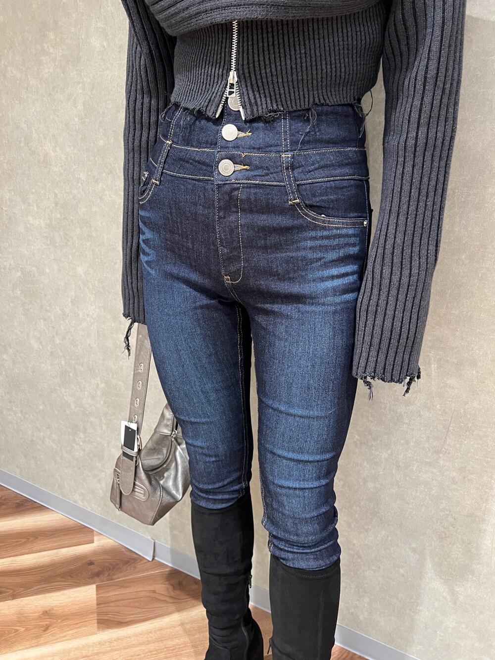 ブラック系のニット/セーター、ブルー系のデニムパンツ、その他のブーツを着用したレディースの秋コーディネートの5枚目の写真