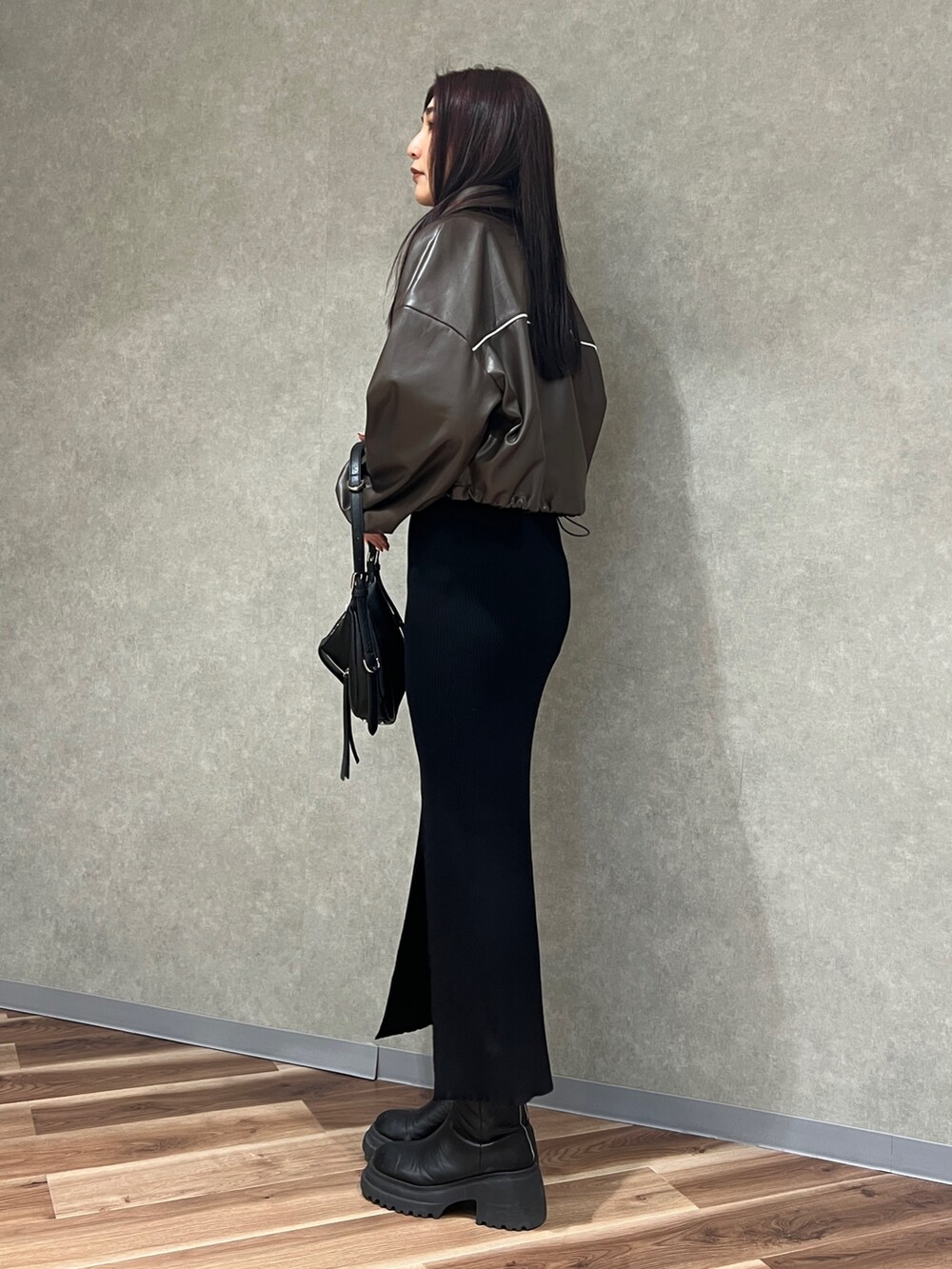 ブラウン系のブルゾン、ブラック系のワンピース、ブラック系のハンドバッグを着用したレディースの冬コーディネートの2枚目の写真