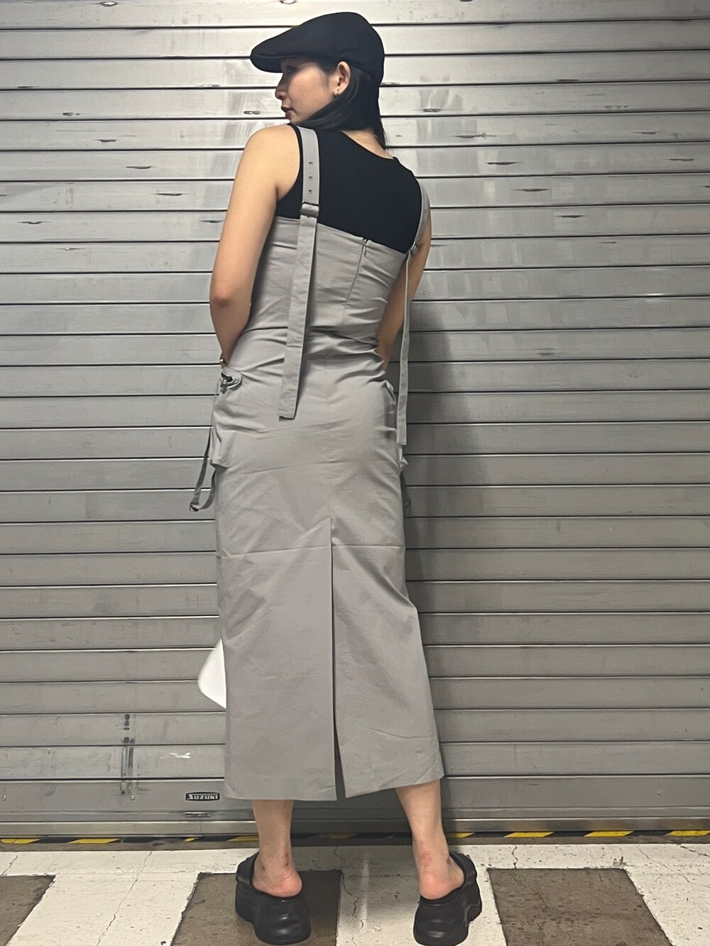 グレー系のワンピース、ホワイト系のハンドバッグ、ブラック系のサンダルを着用したレディースの夏コーディネートの3枚目の写真