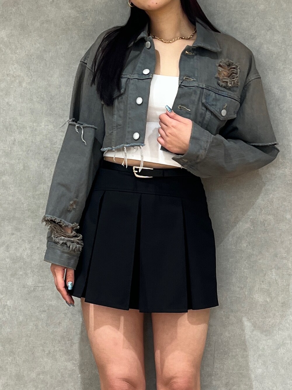 グレー系のデニムジャケット、ホワイト系のキャミソール、ブラック系のスカートを着用したレディースの春コーディネートの3枚目の写真