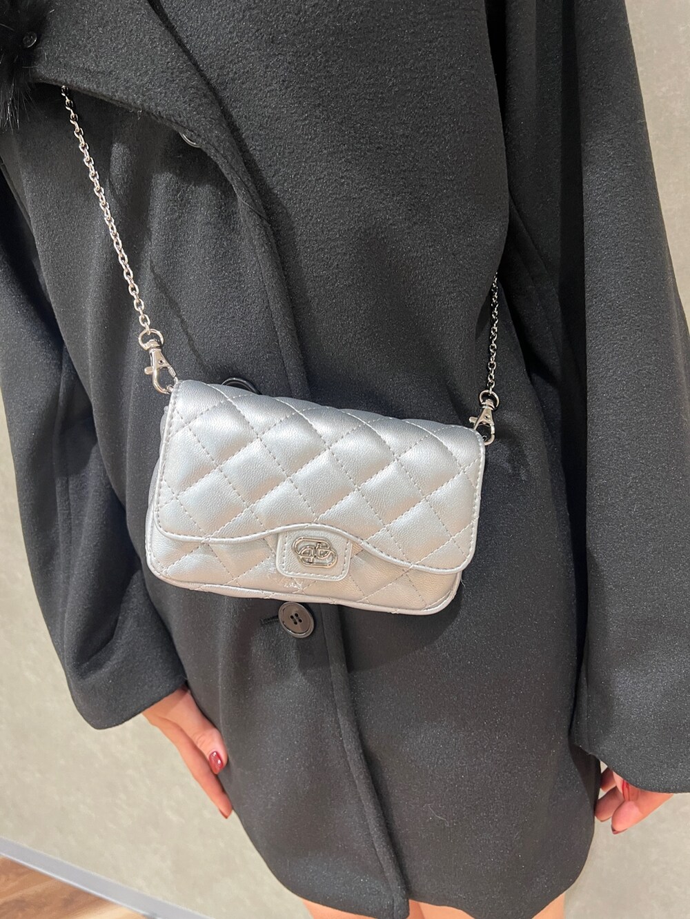 ブラック系のピーコート、その他のブーツ、ブラック系のスカートを着用したレディースの冬コーディネートの6枚目の写真