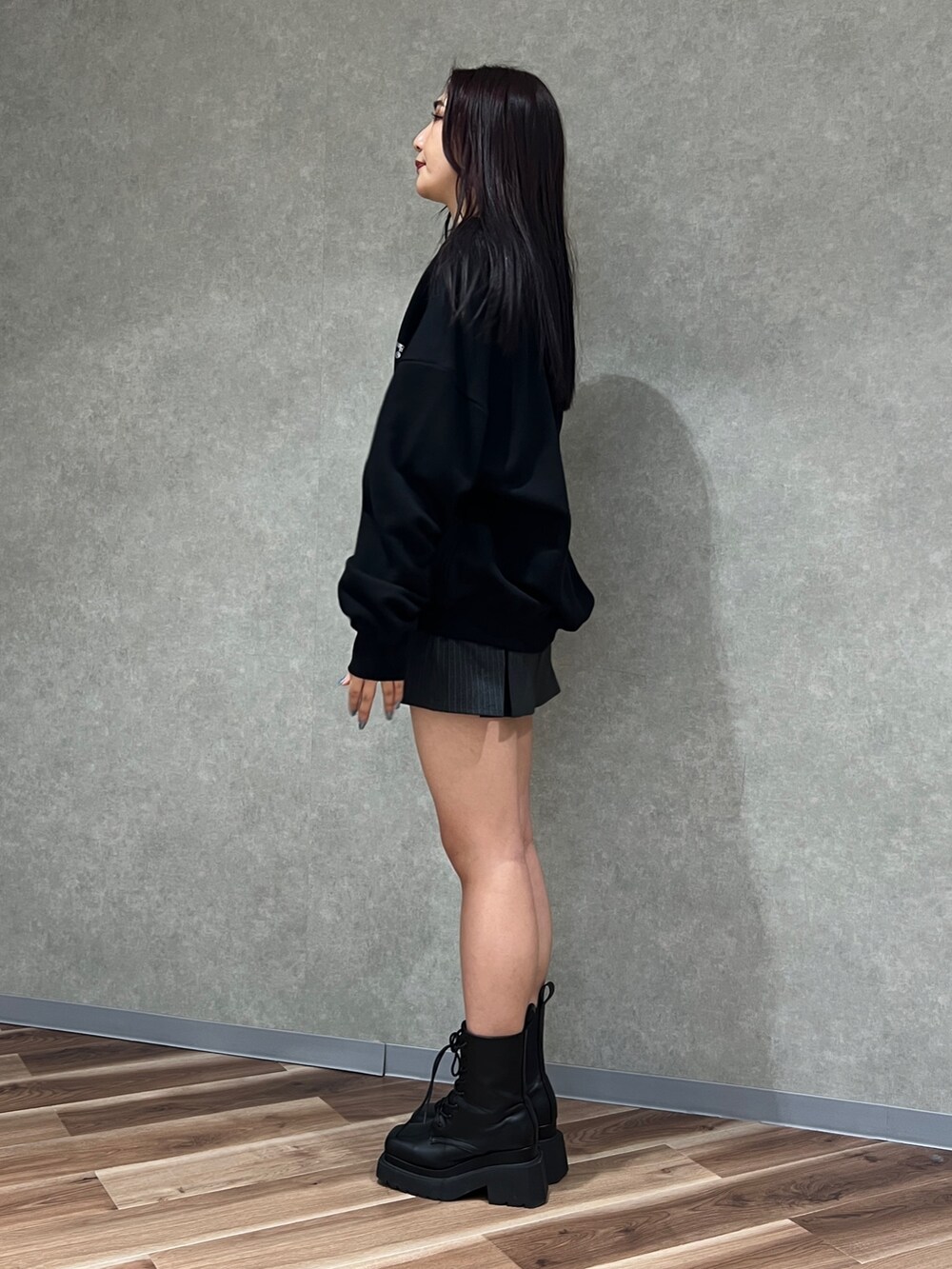 グレー系のスカート、ブラック系のカーディガン/ボレロ、ホワイト系のキャミソールを着用したレディースの春コーディネートの2枚目の写真