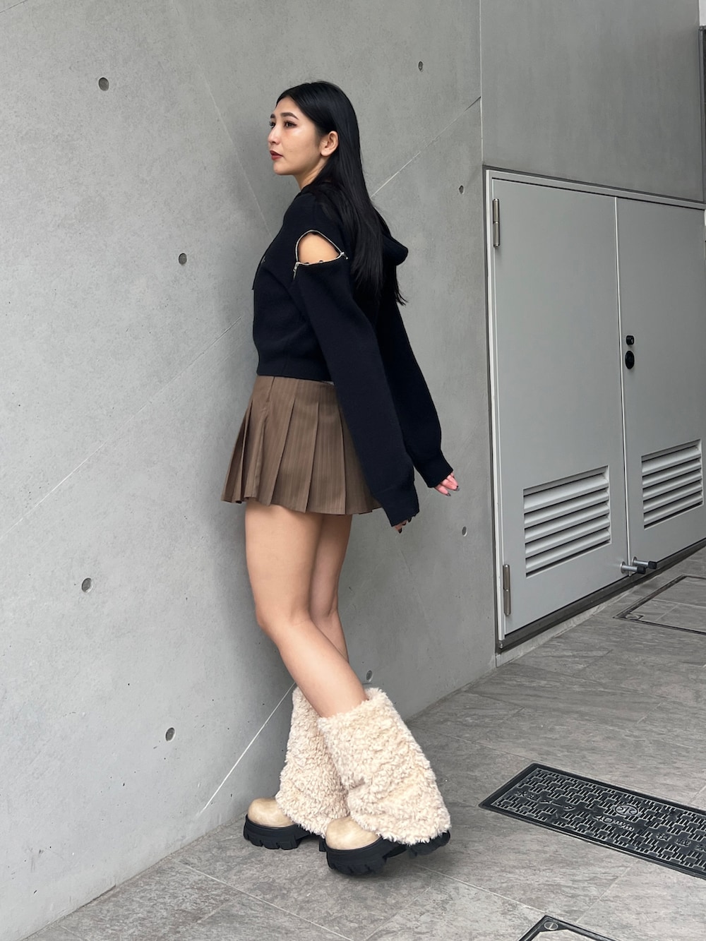 ブラック系のパーカー、ベージュ系のスカート、ホワイト系のブーツを着用したレディースの冬コーディネートの2枚目の写真