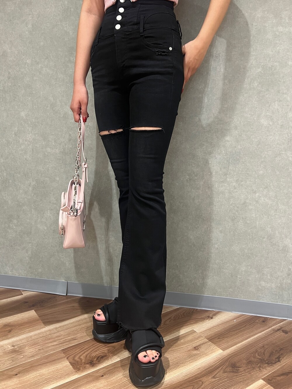 ブラック系のTシャツ/カットソー、ブラック系のデニムパンツ、ブラック系のサンダルを着用したレディースの春コーディネートの4枚目の写真