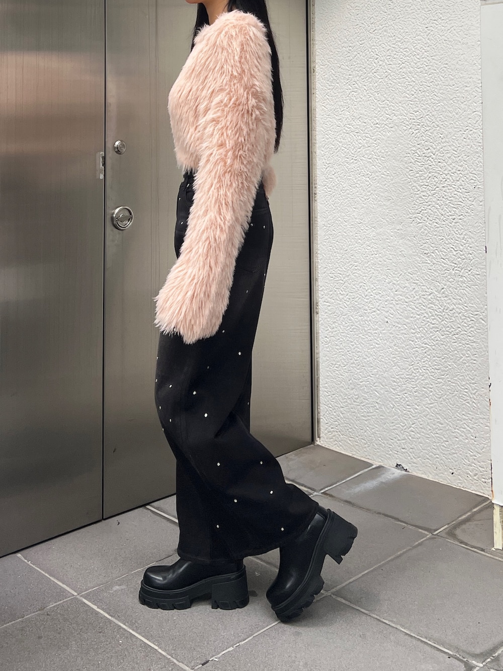 ピンク系のニット/セーター、ブルー系のデニムパンツ、ブラウン系のブーツを着用したレディースの冬コーディネートの2枚目の写真