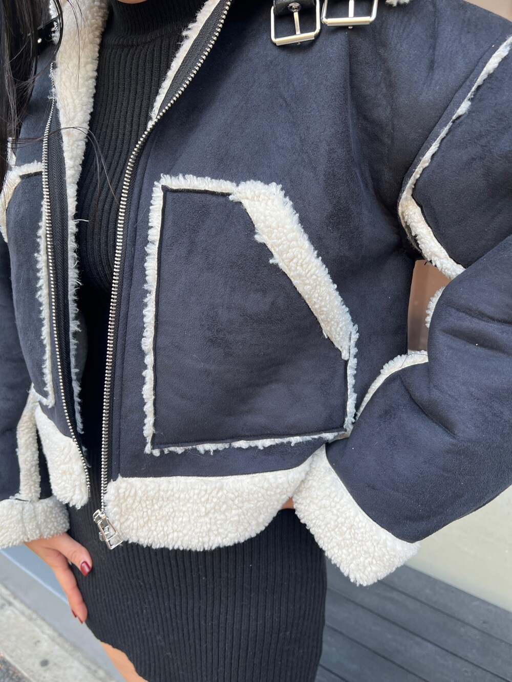 ブラック系のワンピース、ブラック系のブーツ、その他のブルゾンを着用したレディースの冬コーディネートの4枚目の写真