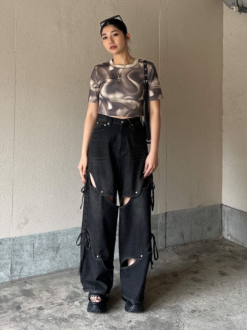 ベージュ系のTシャツ/カットソー、ブラック系のデニムパンツ、ブラック系のサンダルを着用したレディースの春コーディネートの4枚目の写真