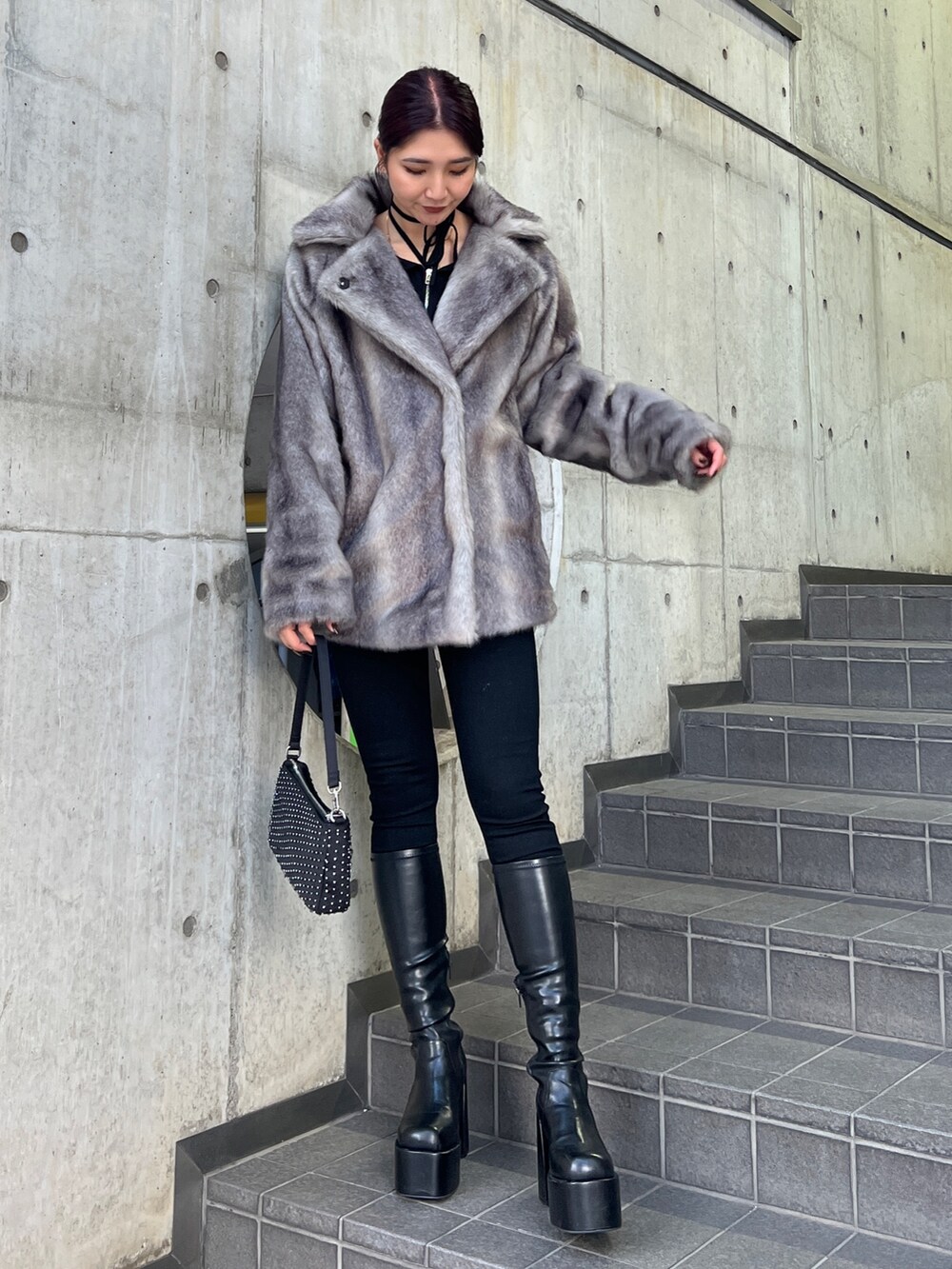 グレー系のその他アウター、ブラック系のニット/セーター、ブラック系のデニムパンツを着用したレディースの冬コーディネートの2枚目の写真