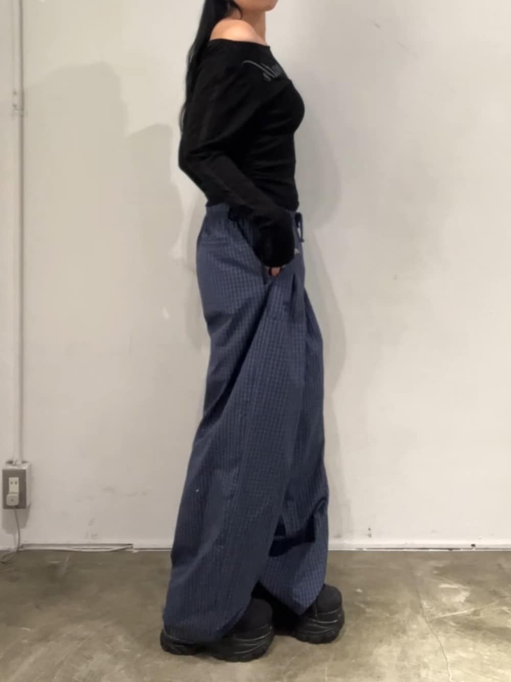 ブルー系のその他パンツ、ブラック系のTシャツ/カットソー、ブラック系のスニーカーを着用したレディースの春コーディネートの2枚目の写真