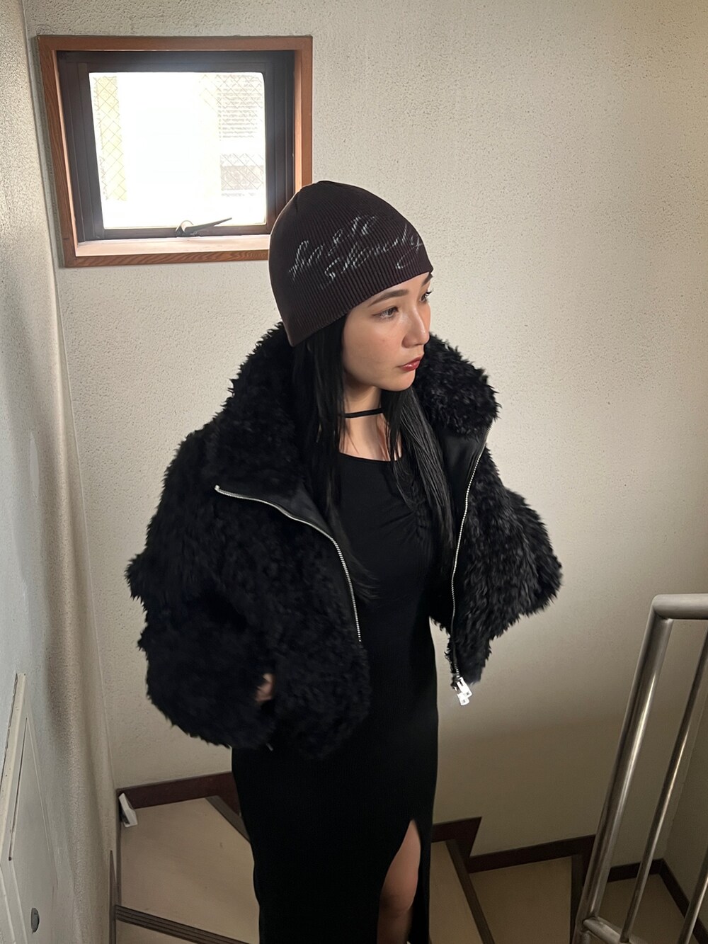 ブラック系のワンピース、ブラック系のブルゾン、ブラック系のブーツを着用したレディースの秋コーディネートの3枚目の写真