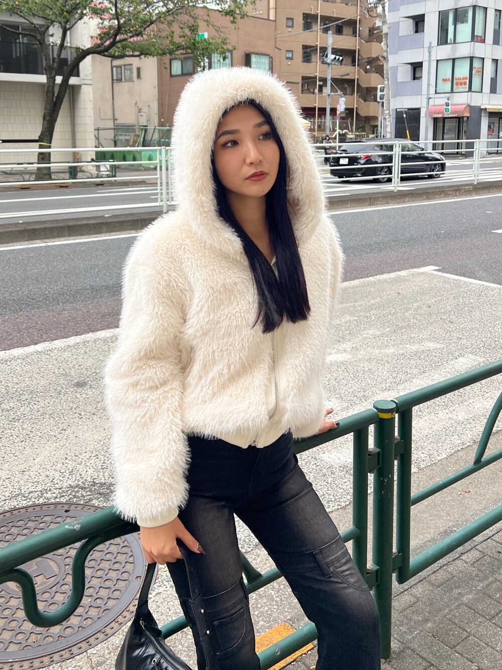 ホワイト系のブルゾン、ブラック系のデニムパンツ、ブラック系のブーツを着用したレディースの秋コーディネートの2枚目の写真