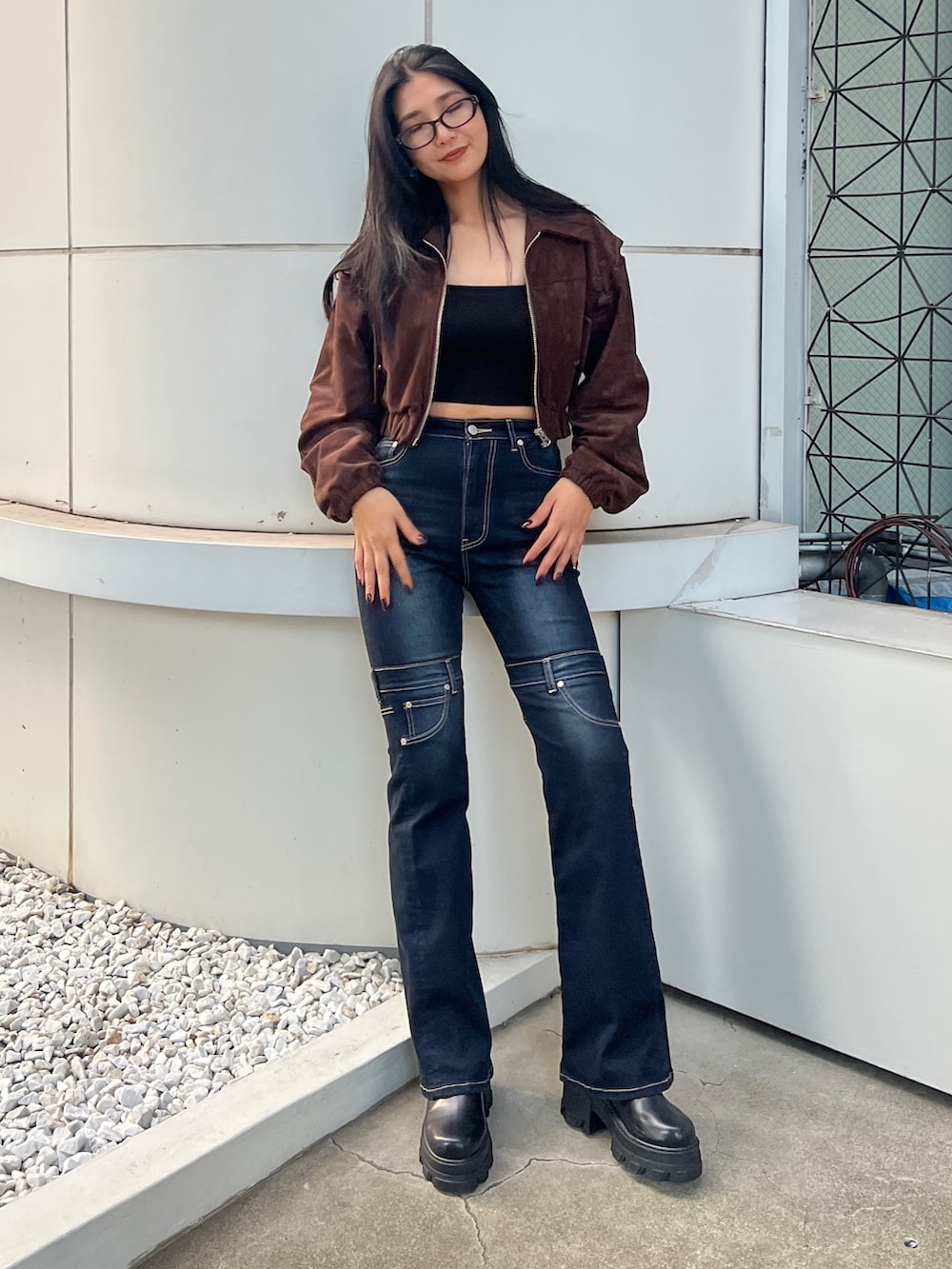 ブラウン系のブルゾン、ブラック系のキャミソール、ブルー系のデニムパンツを着用したレディースの夏コーディネートの3枚目の写真