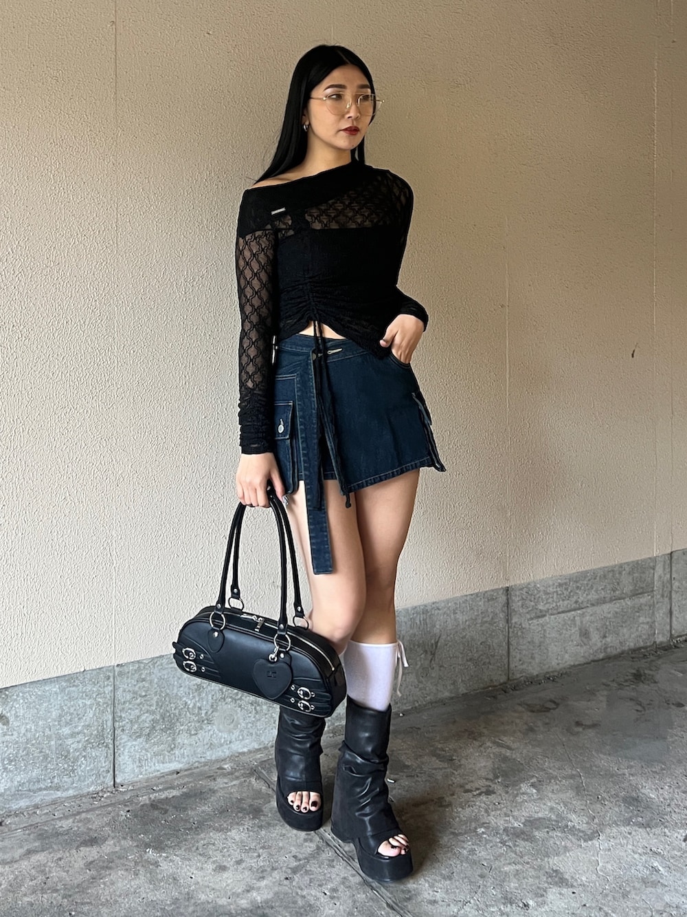 ブラック系のTシャツ/カットソー、ブルー系のスカート、ブラック系のサンダルを着用したレディースの春コーディネートの2枚目の写真