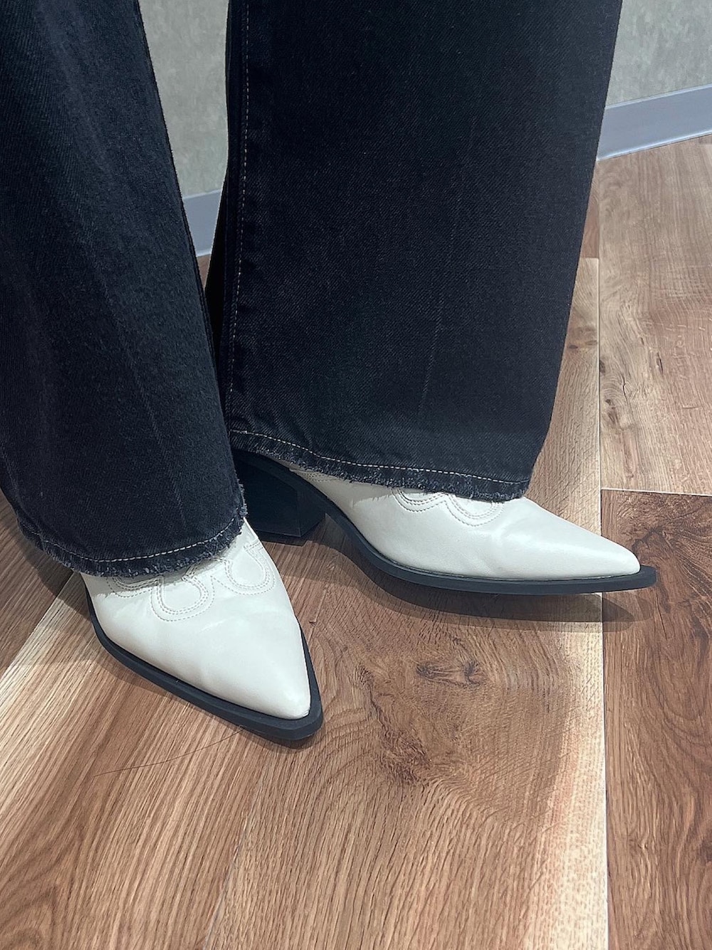 ブルー系のデニムパンツ、ホワイト系のニット/セーター、ホワイト系のブーツを着用したレディースの夏コーディネートの6枚目の写真