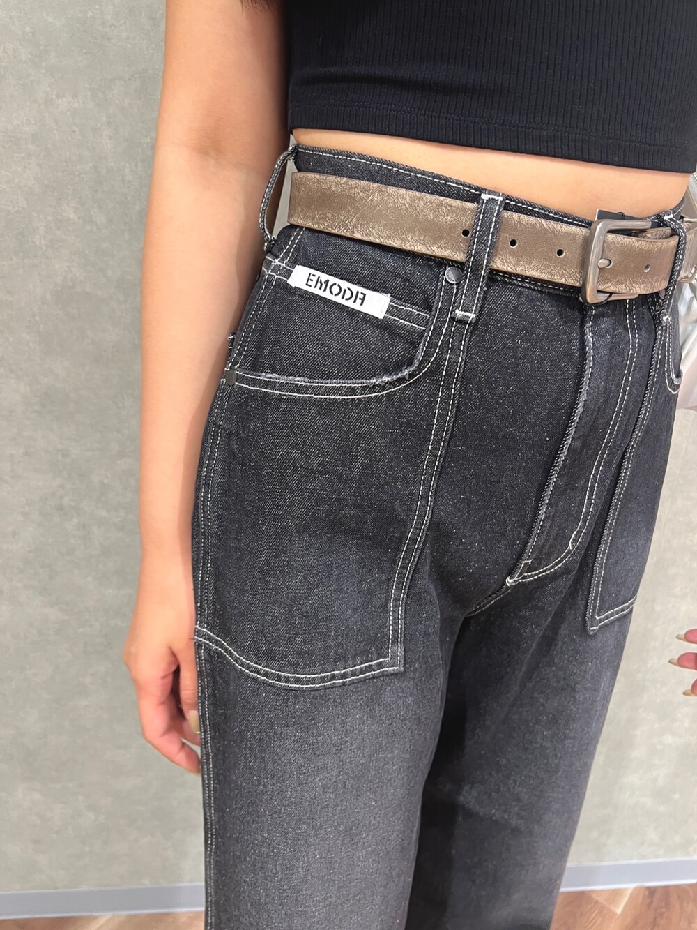 ブラック系のタンクトップ、ブルー系のデニムパンツ、ホワイト系のハンドバッグを着用したレディースの夏コーディネートの6枚目の写真