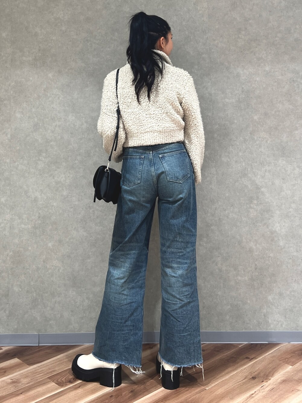 グレー系のニット/セーター、ブルー系のデニムパンツ、ホワイト系のブーツを着用したレディースの秋コーディネートの3枚目の写真