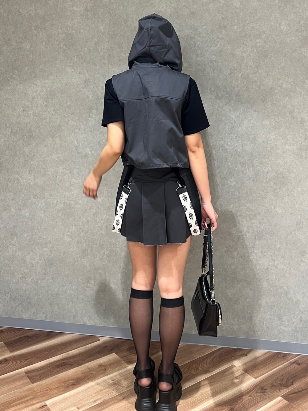 グレー系のベスト、ブラック系のTシャツ/カットソー、グレー系のスカートを着用したレディースの春コーディネートの4枚目の写真