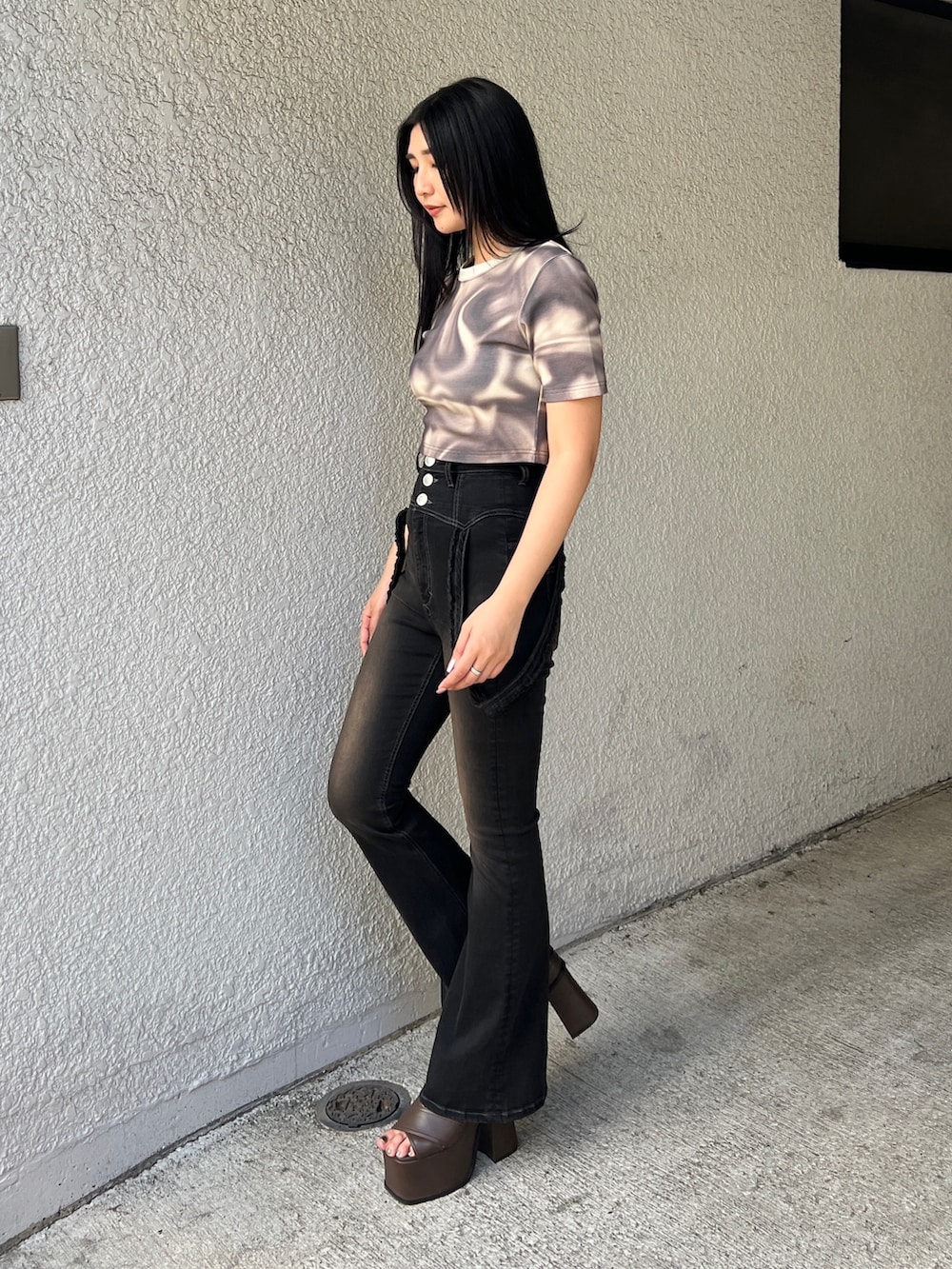 ベージュ系のTシャツ/カットソー、ブラック系のデニムパンツ、ブラウン系のサンダルを着用したレディースの春コーディネートの3枚目の写真