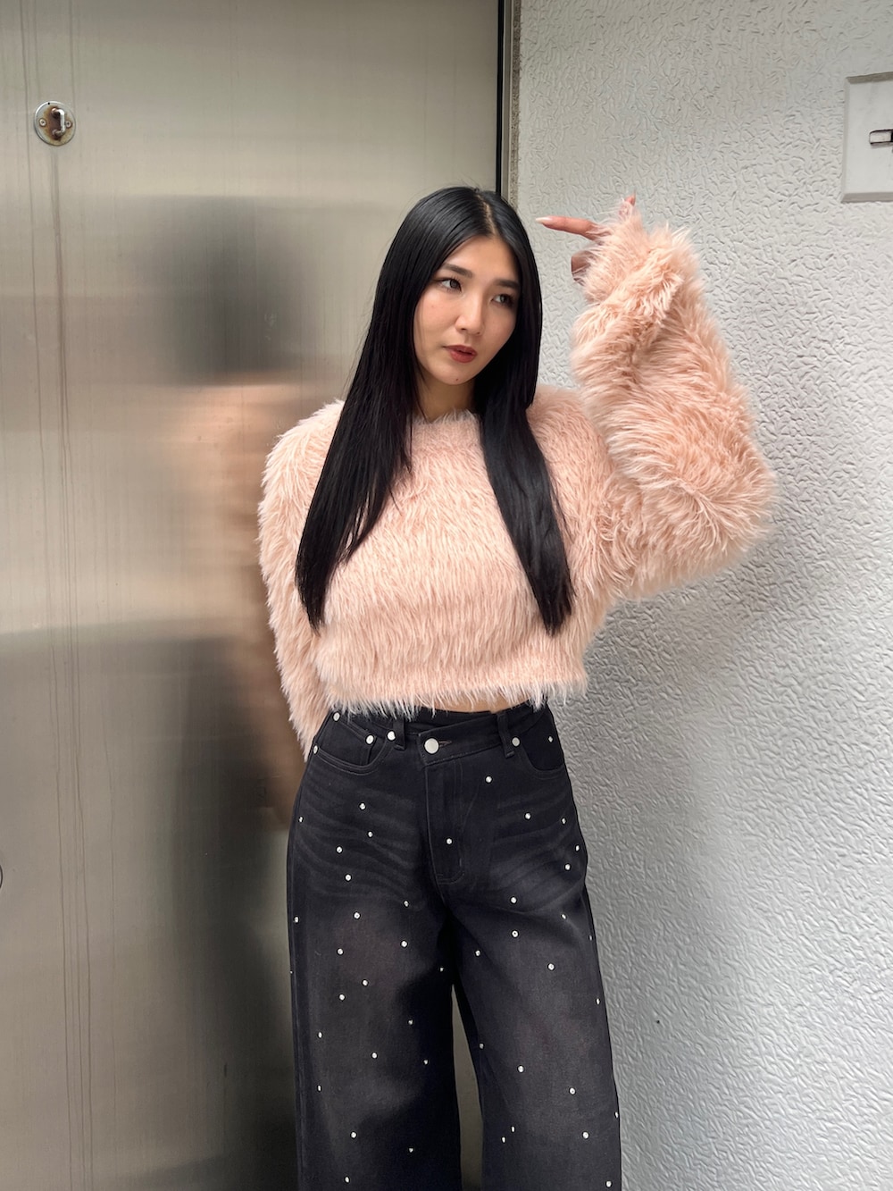 ピンク系のニット/セーター、ブルー系のデニムパンツ、ブラウン系のブーツを着用したレディースの冬コーディネートの4枚目の写真