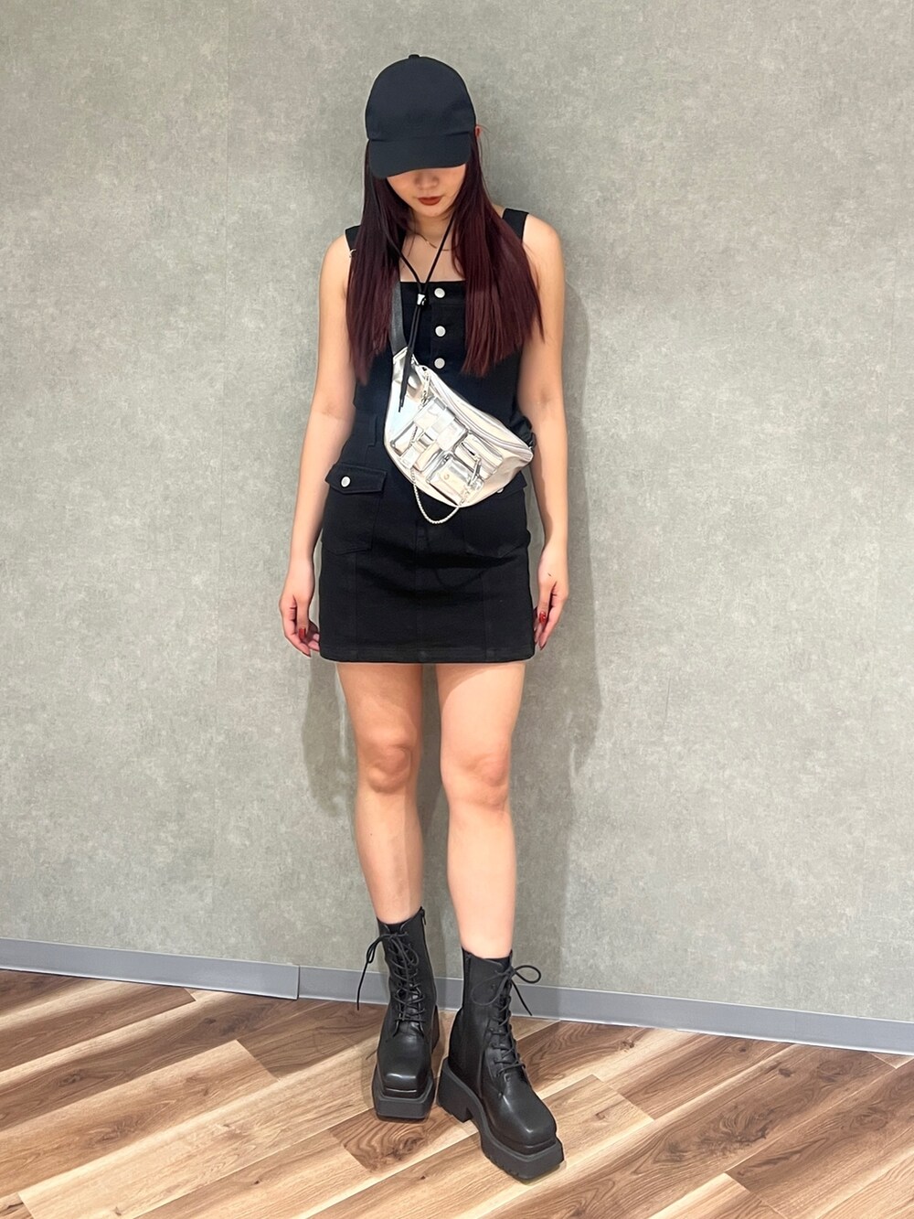 ブラック系のワンピース、ブラック系のブーツ、シルバー系のハンドバッグを着用したレディースの春コーディネートの2枚目の写真