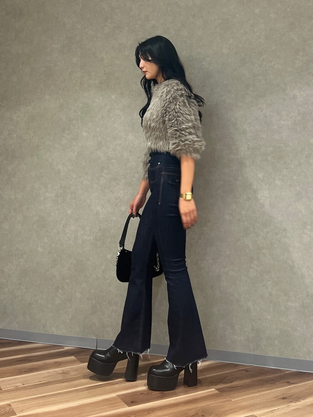 グレー系のニット/セーター、ブルー系のデニムパンツ、ブラック系のハンドバッグを着用したレディースの秋コーディネートの3枚目の写真
