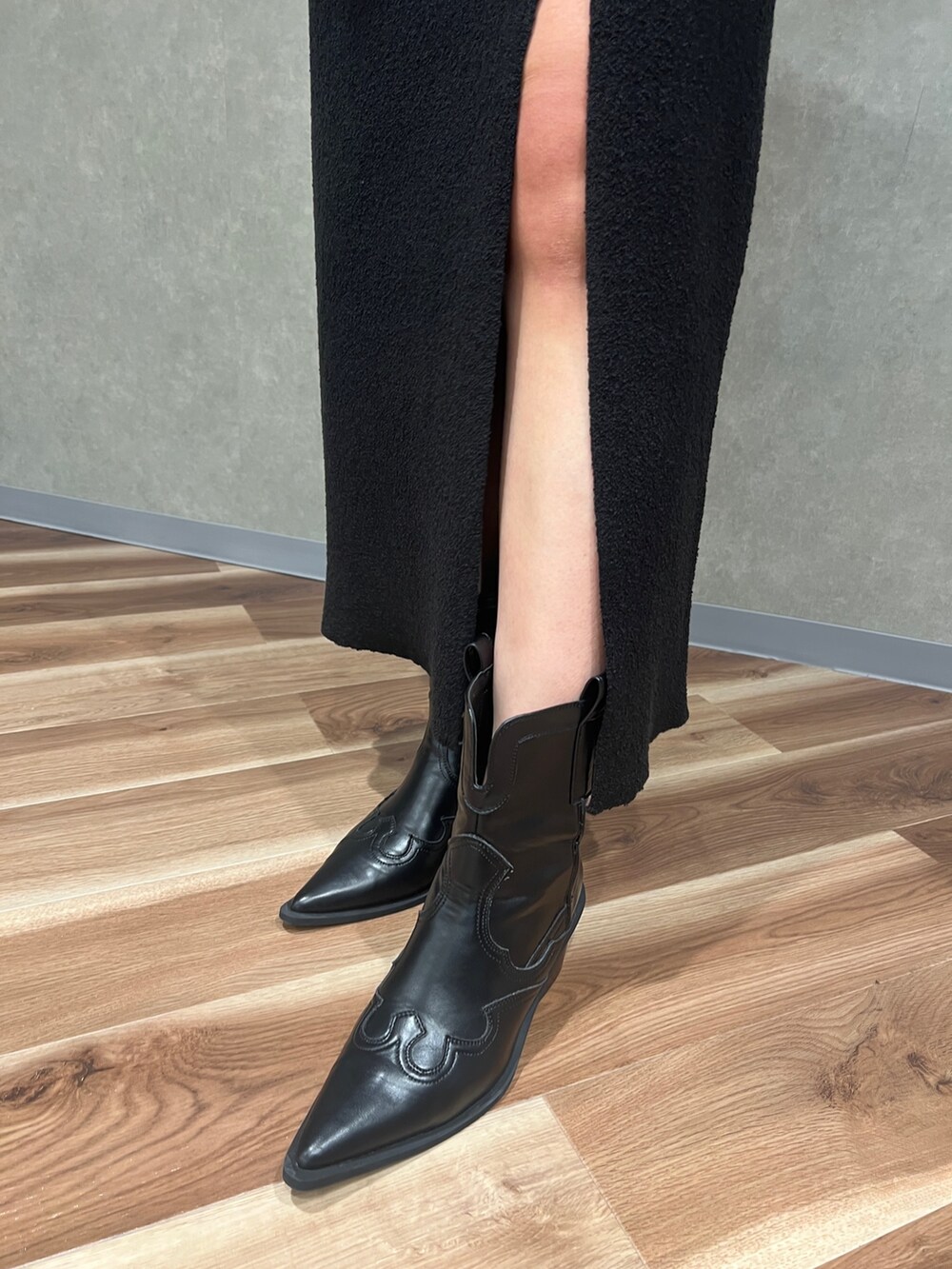 ブラック系のスカート、シルバー系のショルダーバッグ、ブラック系のブーツを着用したレディースの夏コーディネートの6枚目の写真