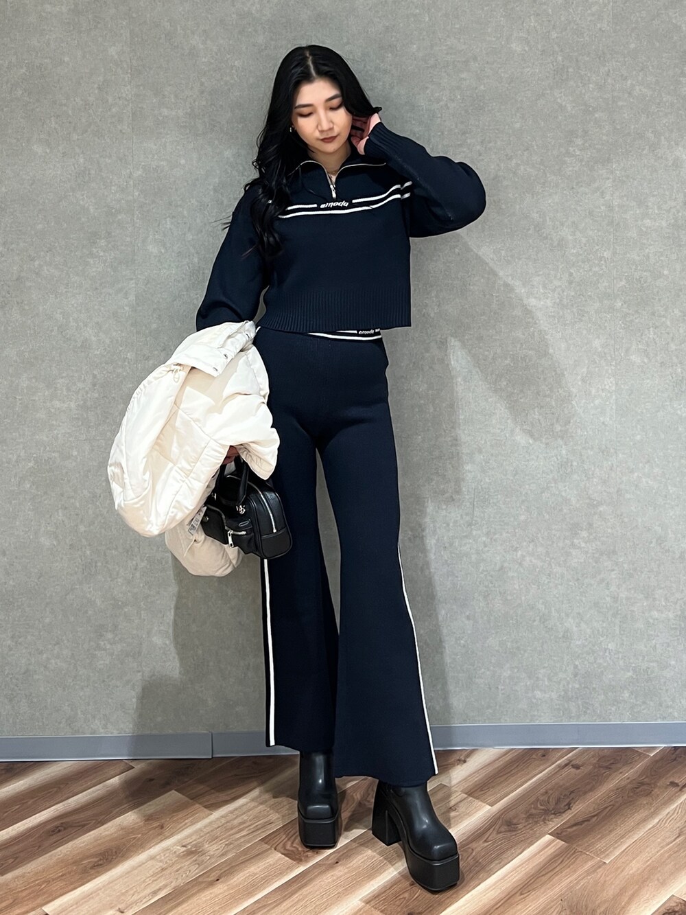 ホワイト系のブルゾン、ブラック系のニット/セーター、ブルー系のその他パンツを着用したレディースの秋コーディネートの10枚目の写真