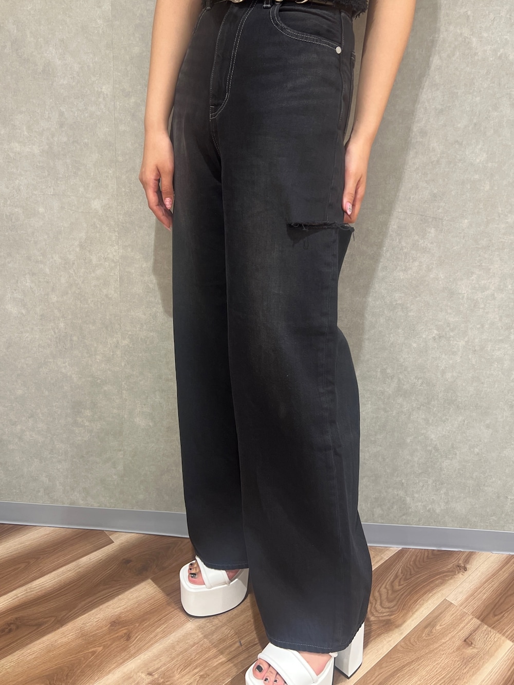 ブラック系のタンクトップ、ブラック系のデニムパンツ、ホワイト系のサンダルを着用したレディースの夏コーディネートの8枚目の写真