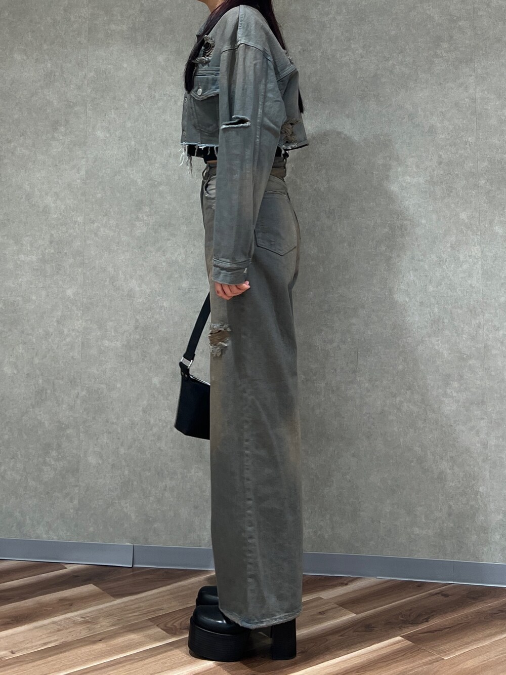 グレー系のデニムジャケット、グレー系のデニムパンツ、ブラック系のブーツを着用したレディースの冬コーディネートの2枚目の写真