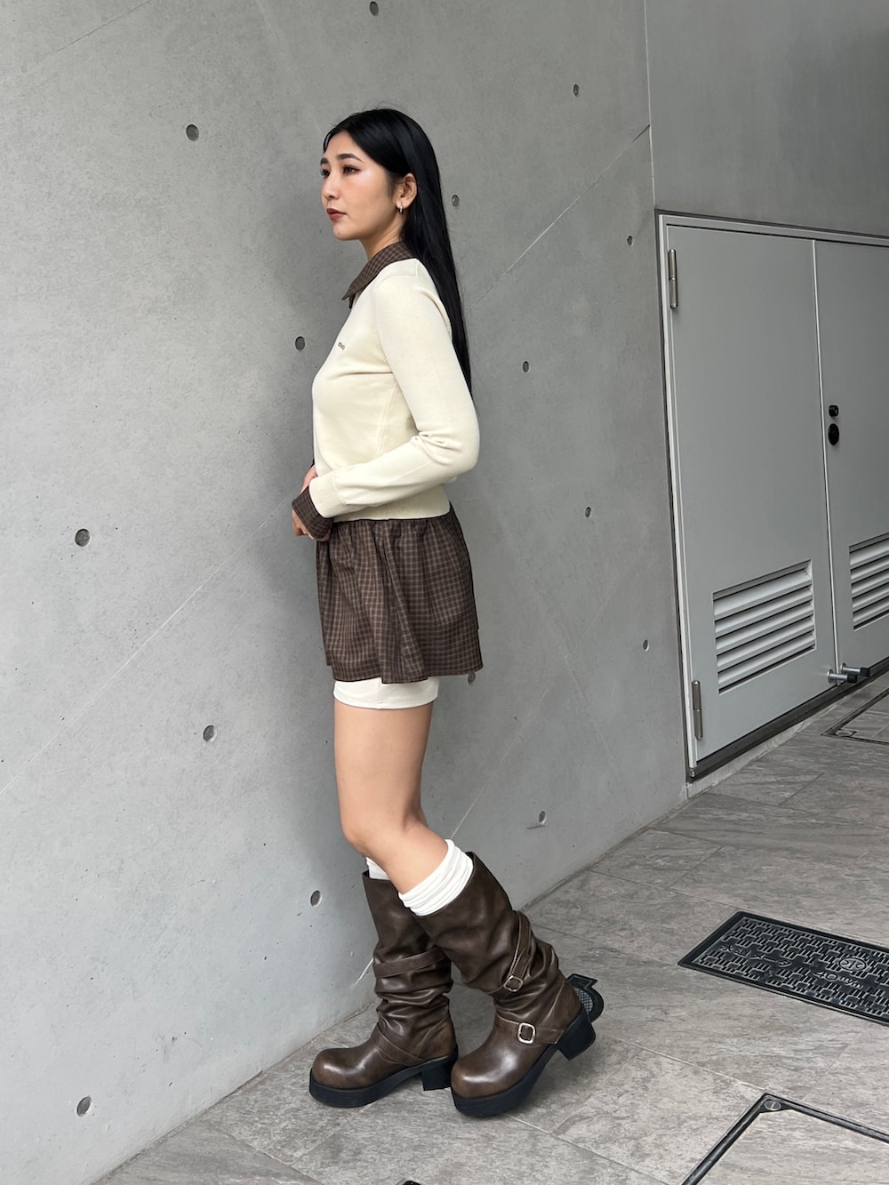 ベージュ系のニット/セーター、ベージュ系のスカート、ブラウン系のブーツを着用したレディースの秋コーディネートの3枚目の写真