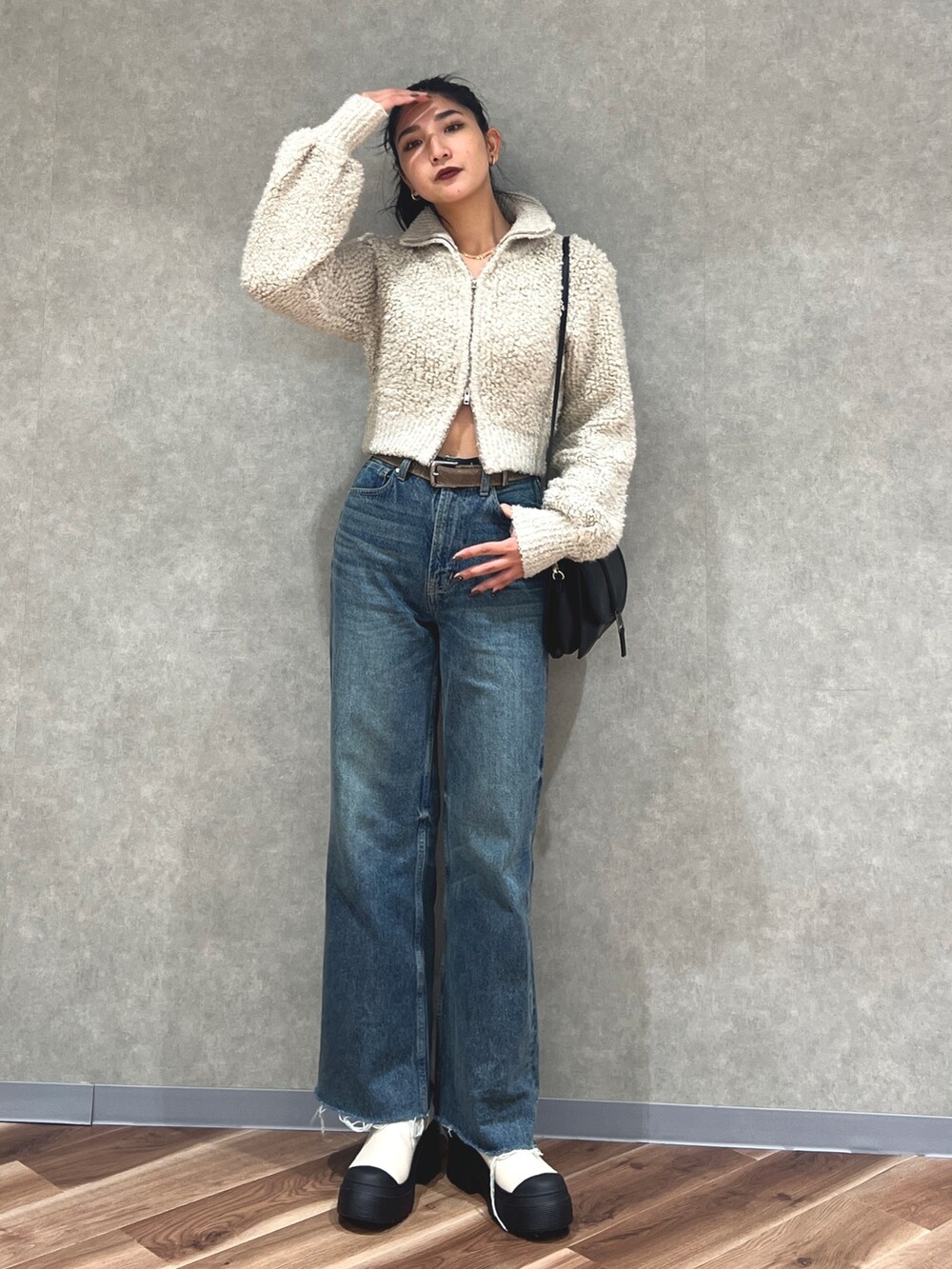 グレー系のニット/セーター、ブルー系のデニムパンツ、ホワイト系のブーツを着用したレディースの秋コーディネートの4枚目の写真