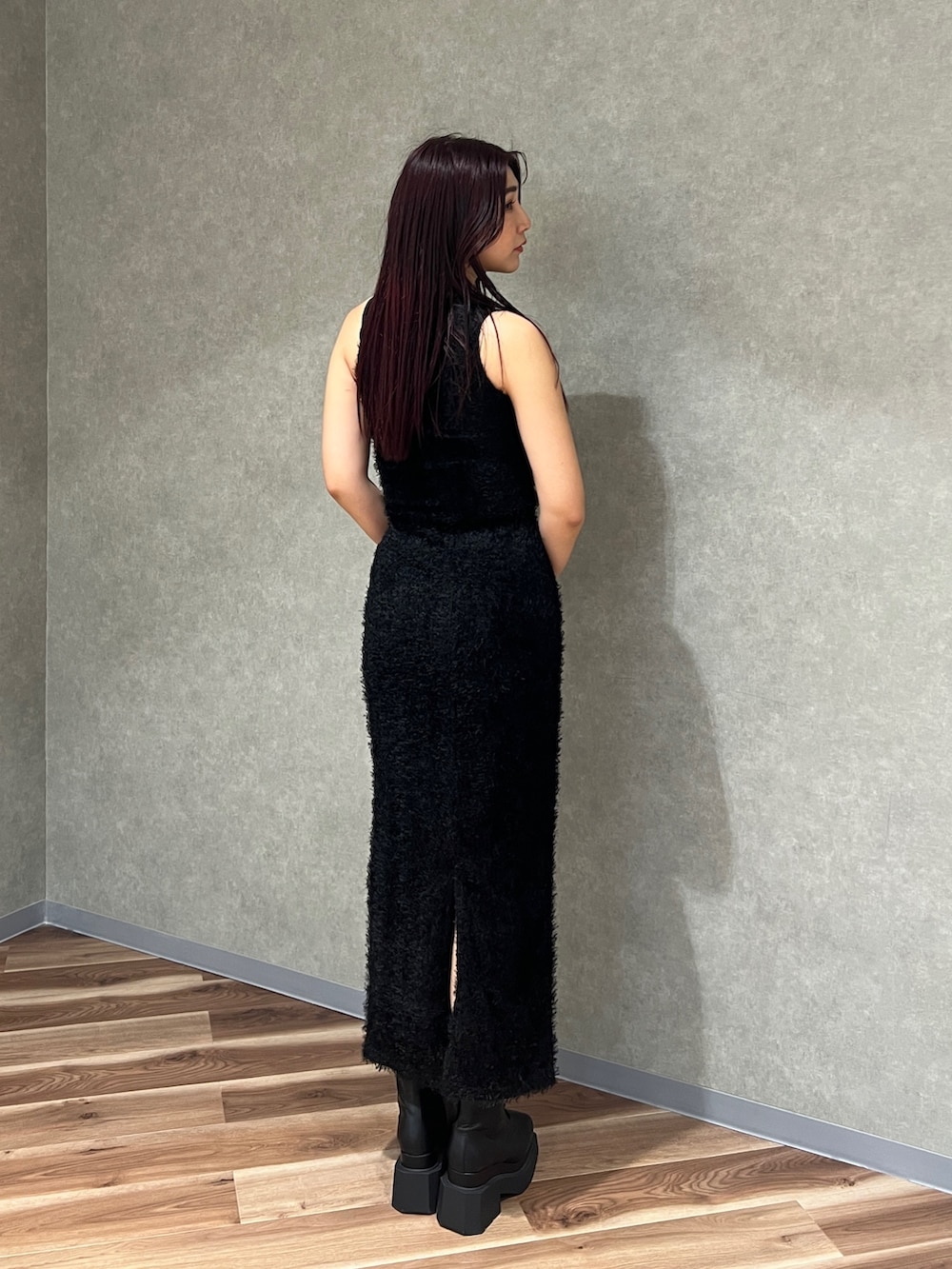 ブラック系のタンクトップ、ブラック系のスカート、ブラック系のブーツを着用したレディースの春コーディネートの4枚目の写真