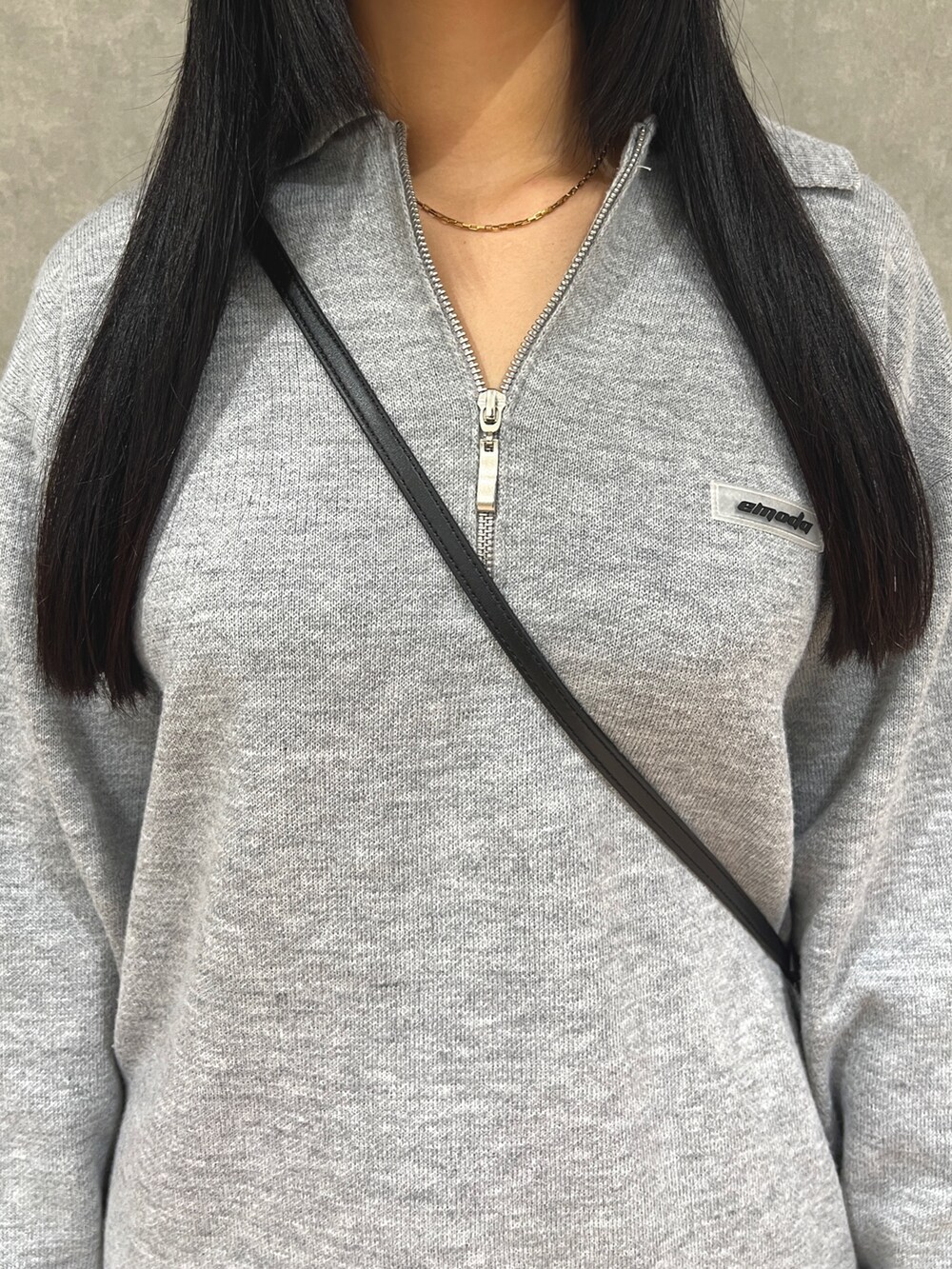 グレー系のワンピース、ブラック系のスカート、ブラック系のブーツを着用したレディースの秋コーディネートの4枚目の写真