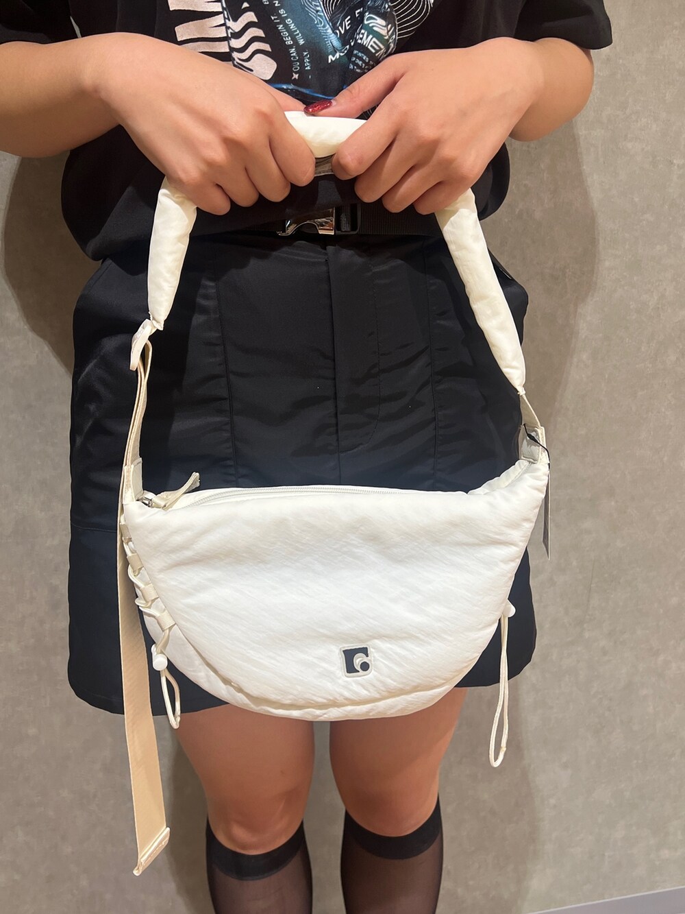 ブラック系のTシャツ/カットソー、ブラック系のスカート、ブラック系のサンダルを着用したレディースの春コーディネートの6枚目の写真