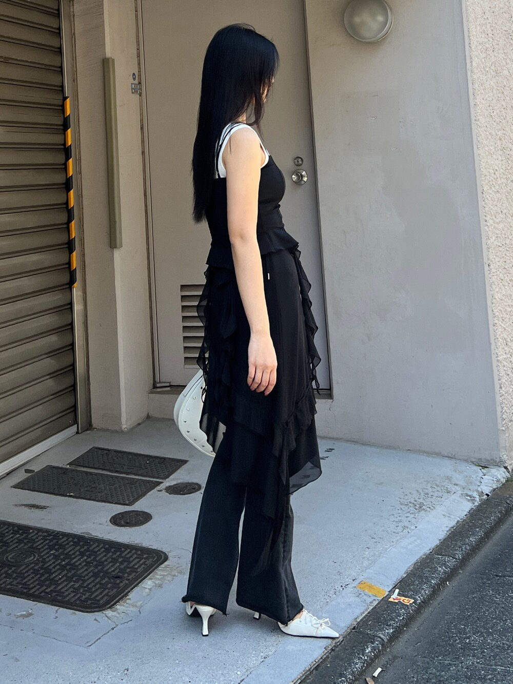 ブラック系のTシャツ/カットソー、ブラック系のスカート、ブラック系のデニムパンツを着用したレディースの春コーディネートの4枚目の写真