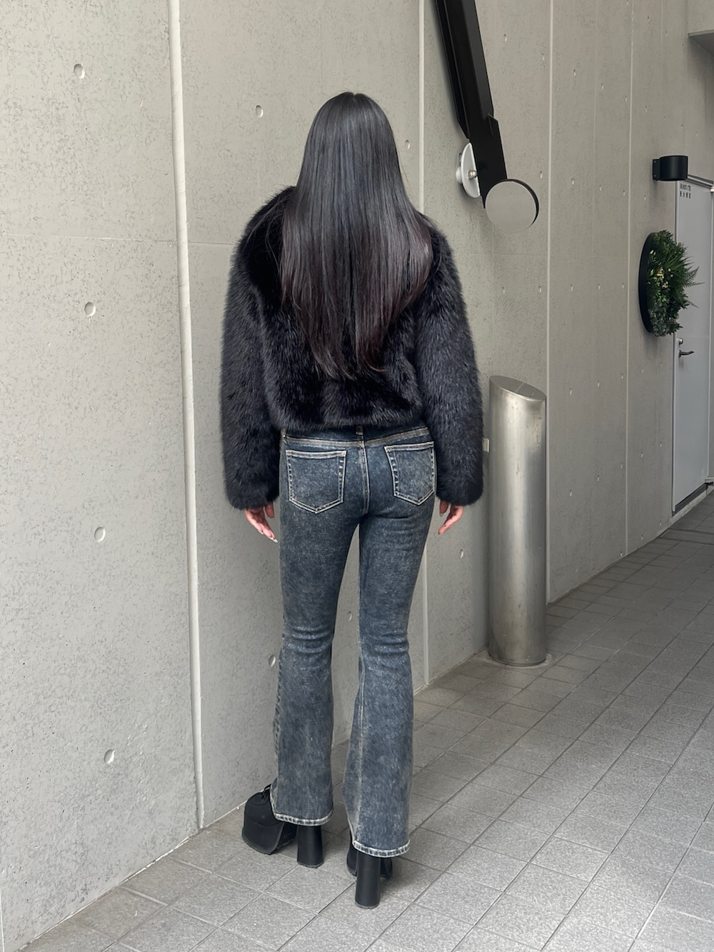ブラック系のブルゾン、ブルー系のニット/セーター、ブルー系のデニムパンツを着用したレディースの秋コーディネートの3枚目の写真