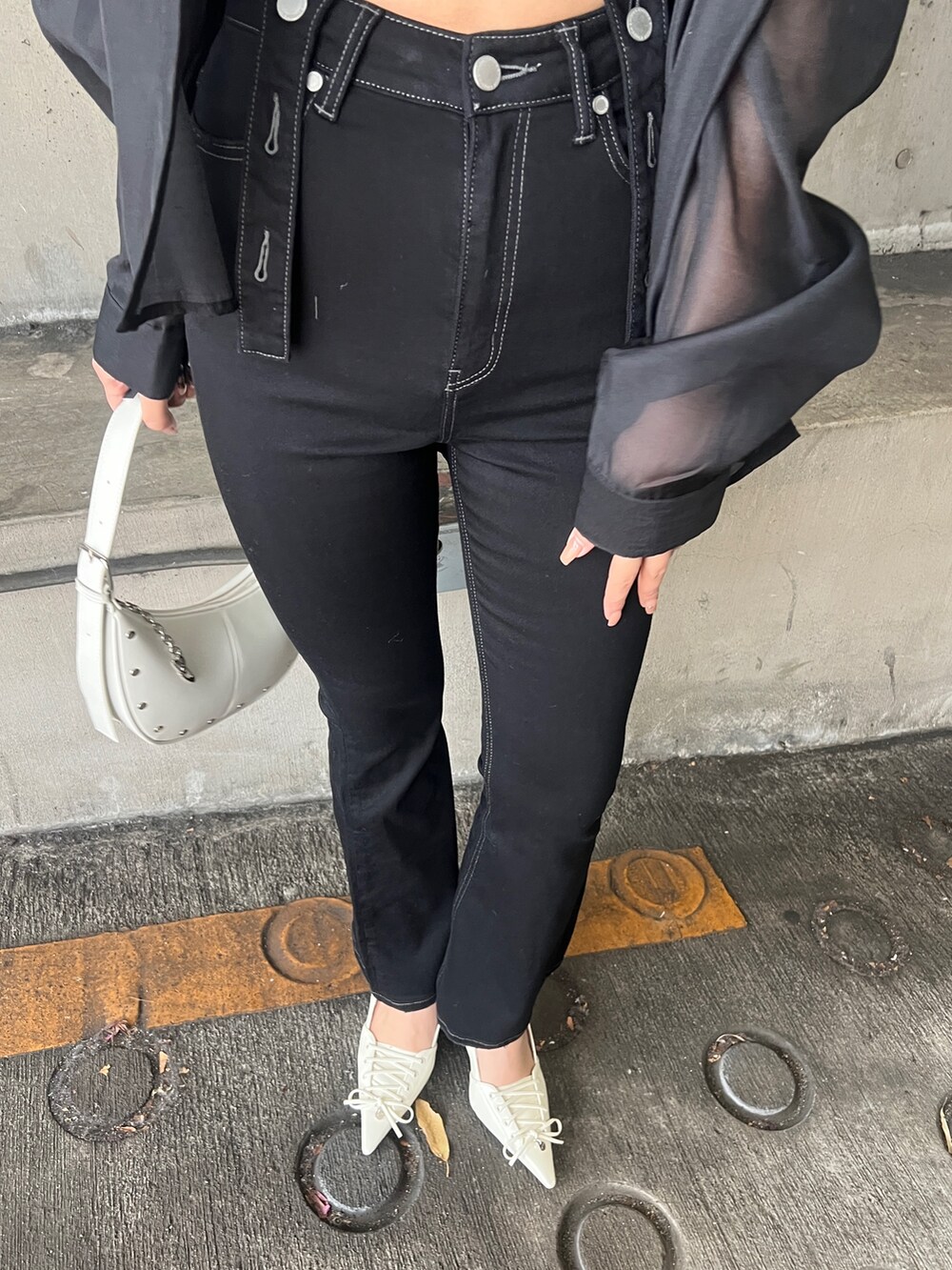 グレー系のシャツ/ブラウス、ブラック系のサロペット/オーバーオール、ホワイト系のパンプスを着用したレディースの春コーディネートの6枚目の写真