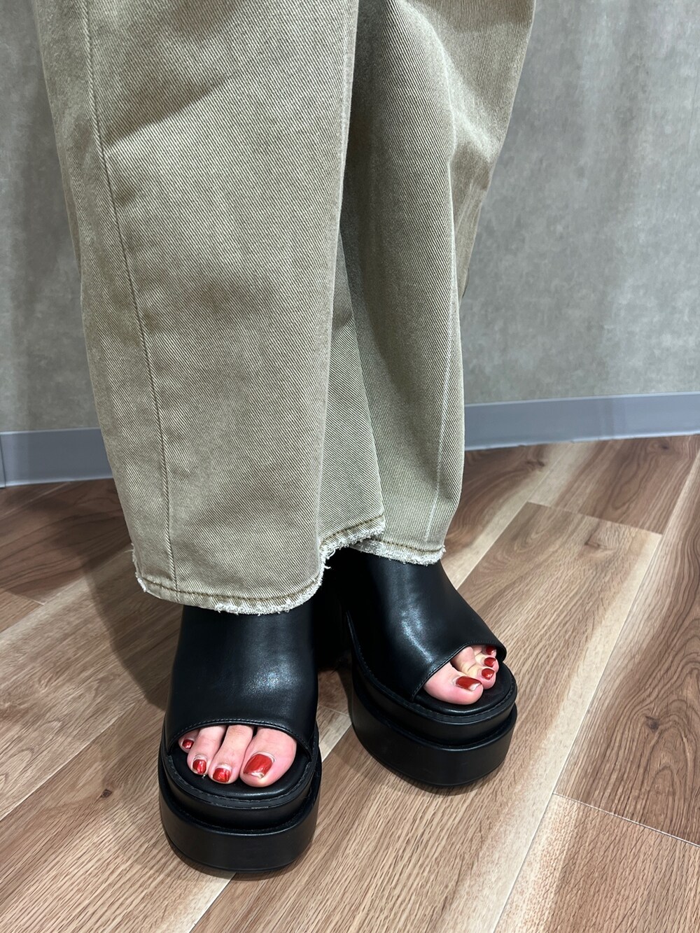 ブラック系のベスト、ホワイト系のニット/セーター、ベージュ系のデニムパンツを着用したレディースの夏コーディネートの7枚目の写真