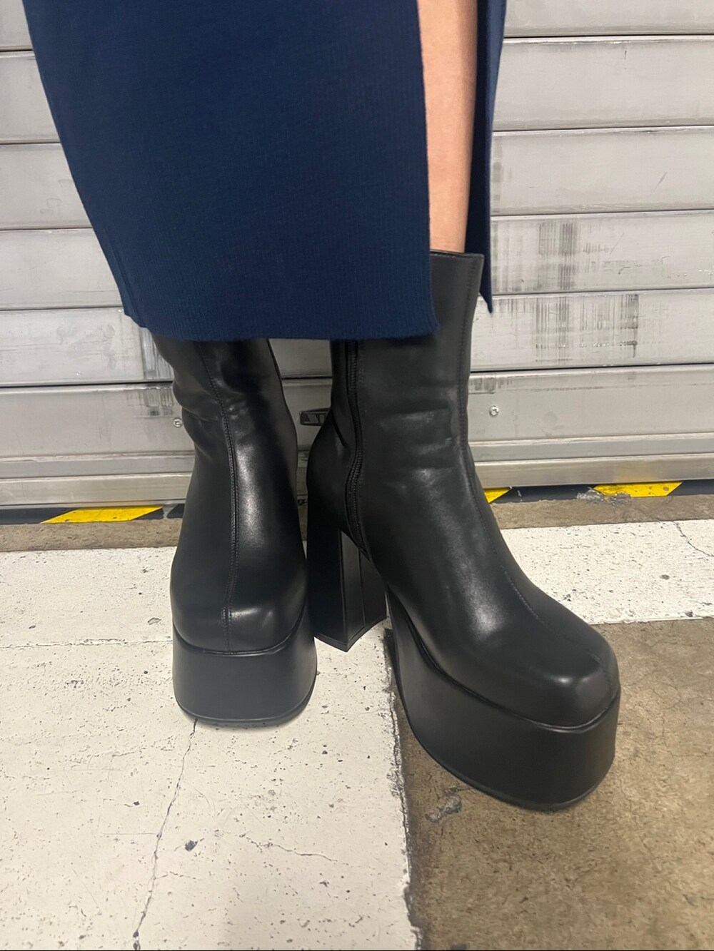 ブルー系のワンピース、ブラック系のブーツ、ゴールド系のネックレスを着用したレディースの秋コーディネートの6枚目の写真