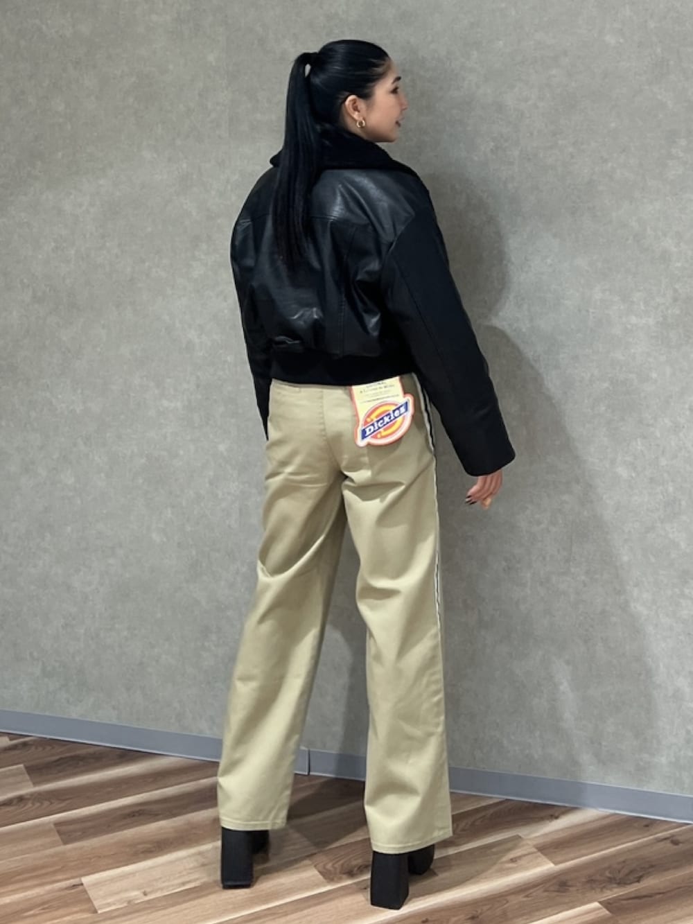 ブラック系のブルゾン、ブラック系のブーツ、ブラック系のニット/セーターを着用したレディースの秋コーディネートの2枚目の写真