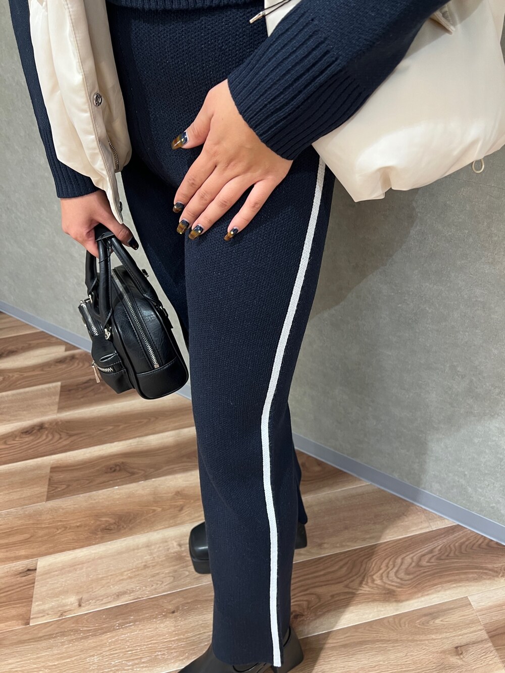 ホワイト系のブルゾン、ブラック系のニット/セーター、ブルー系のその他パンツを着用したレディースの秋コーディネートの7枚目の写真