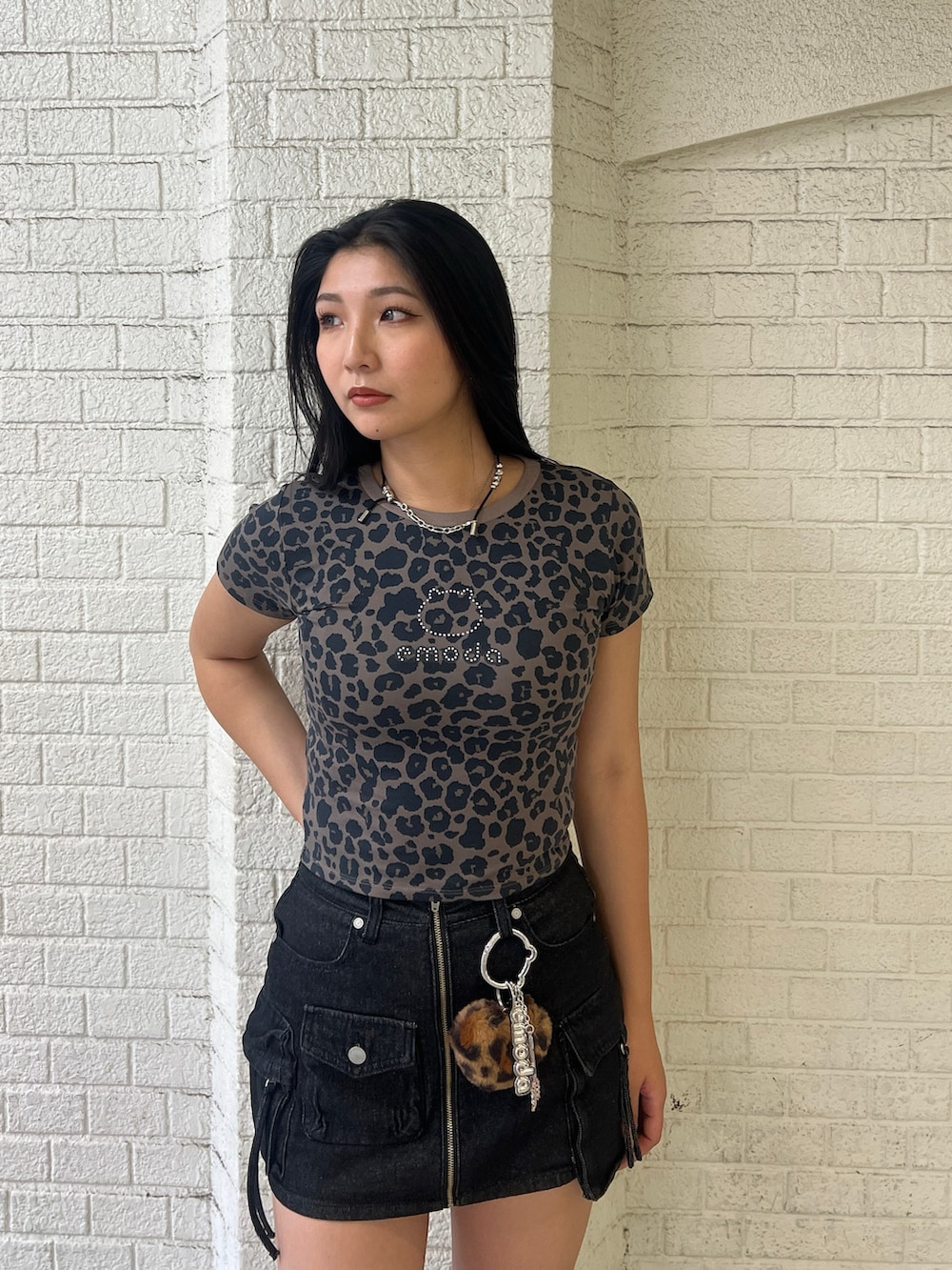 ブラウン系のTシャツ/カットソー、ブラック系のスカート、ブラック系のブーツを着用したレディースの夏コーディネートの4枚目の写真