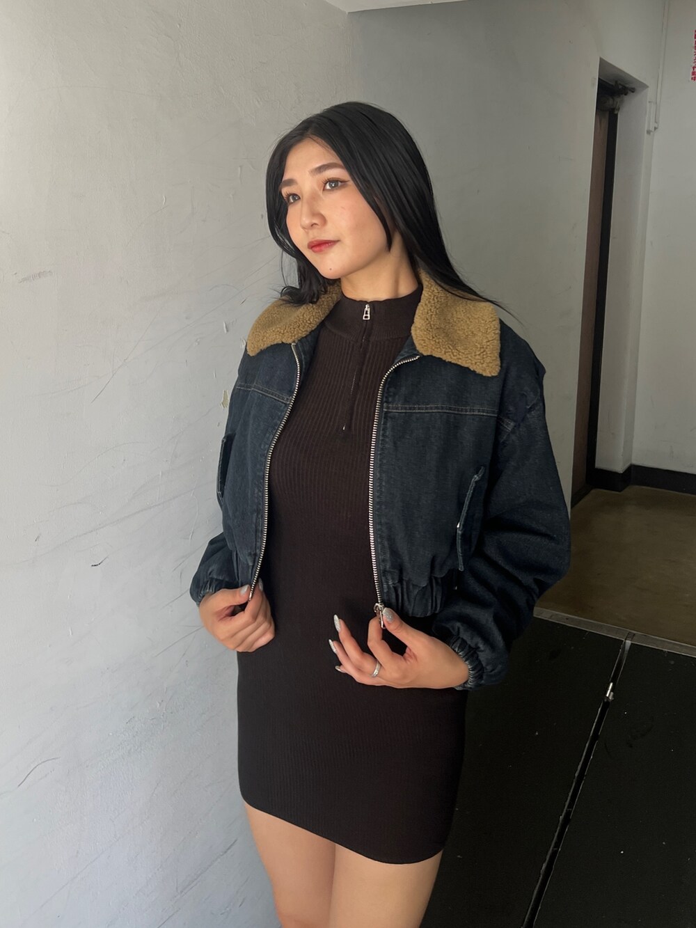 ブルー系のブルゾン、ブラウン系のワンピース、ブラック系のブーツを着用したレディースの夏コーディネートの5枚目の写真