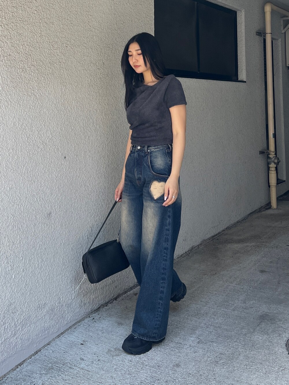 グレー系のTシャツ/カットソー、ブルー系のデニムパンツ、ブラック系のスニーカーを着用したレディースの夏コーディネートの2枚目の写真